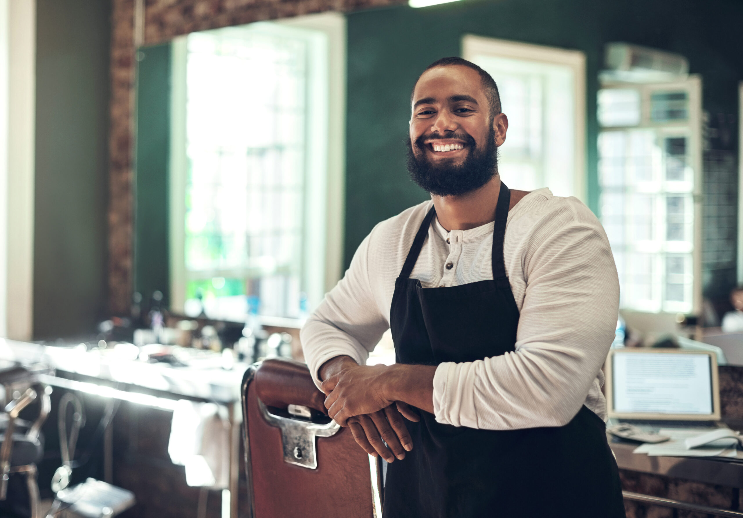 A barber poses in his barbershop