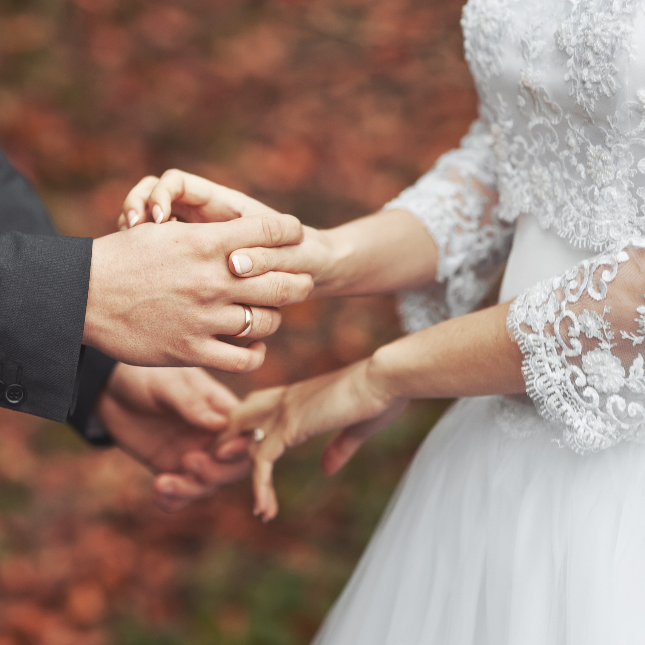Affectionate Couple Holds Hands During Wedding Ceremony