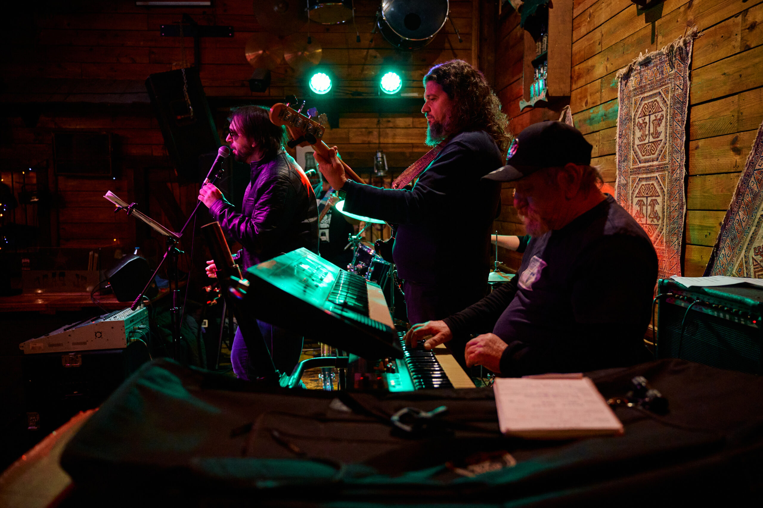 Band Performs on Stage Under Bright Green Lighting
