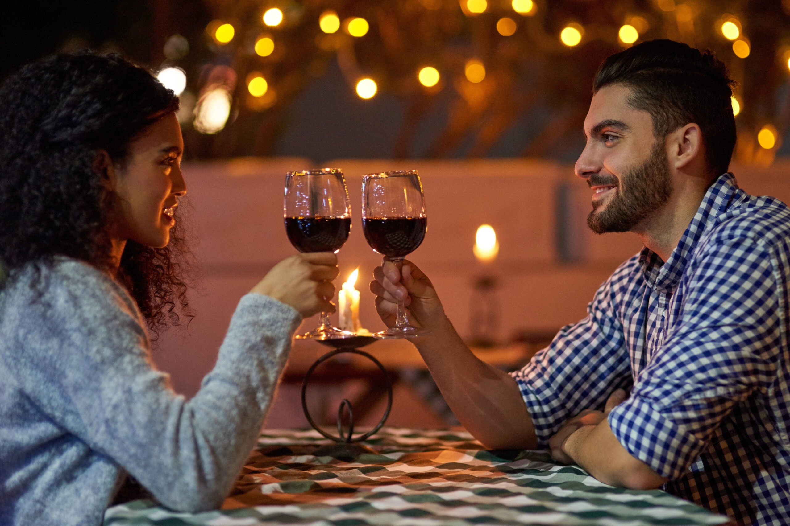 Happy Couple Celebrate With Wine Under Twinkling Lights 