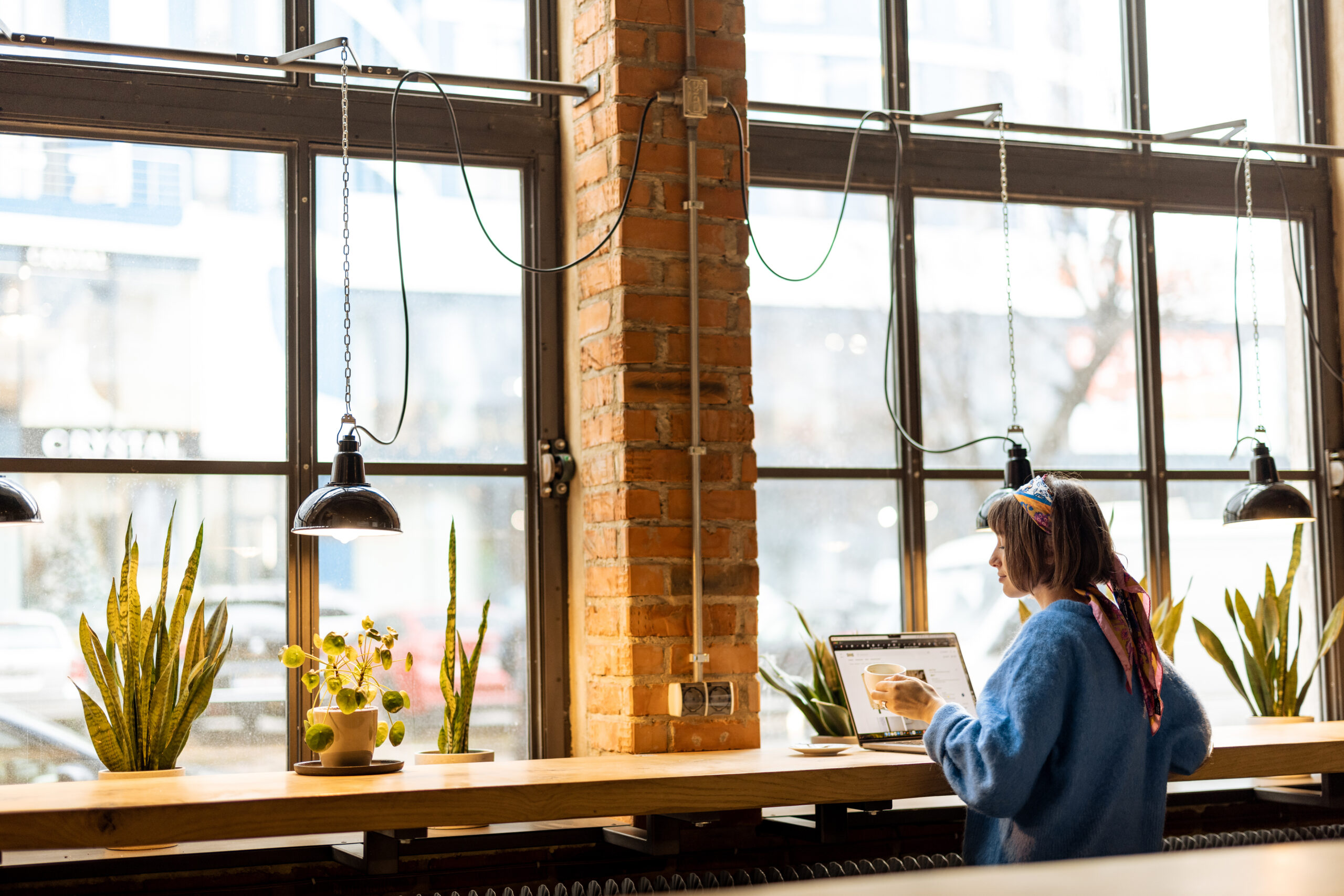 Woman works on laptop at coffee shop
