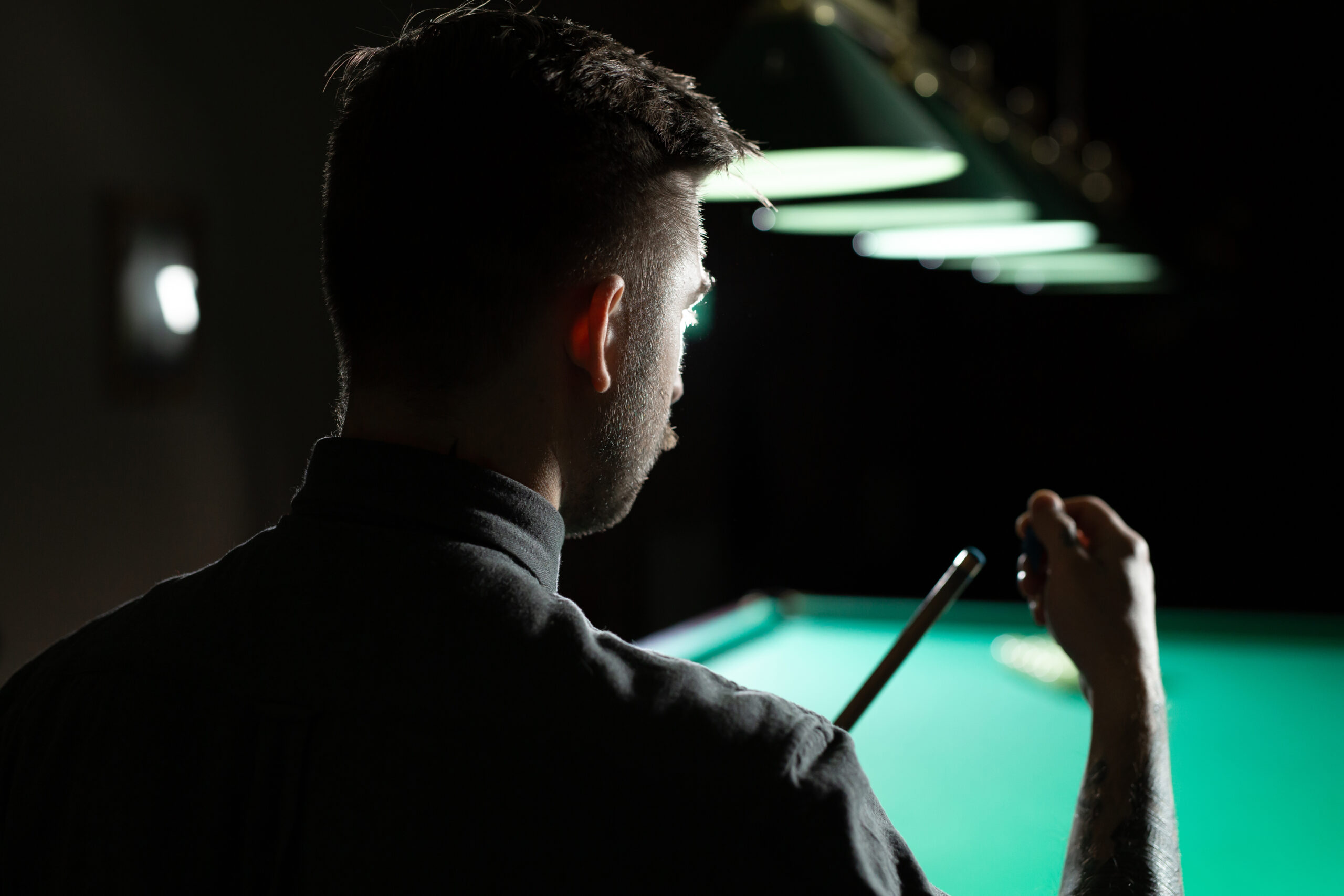 A man holding a cue at one of the snooker clubs in Brighton