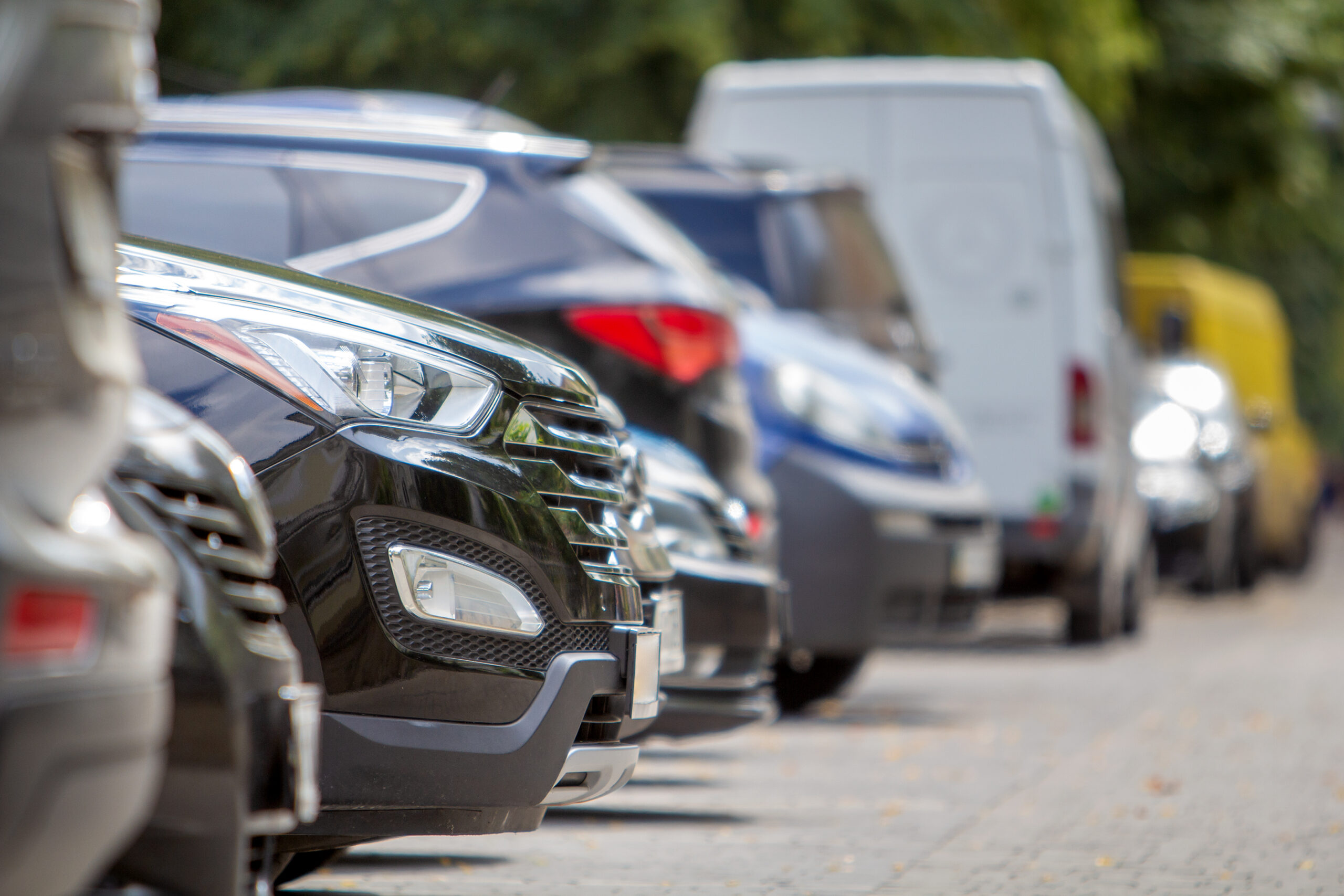Row of cars parked near curb on the side of the street
