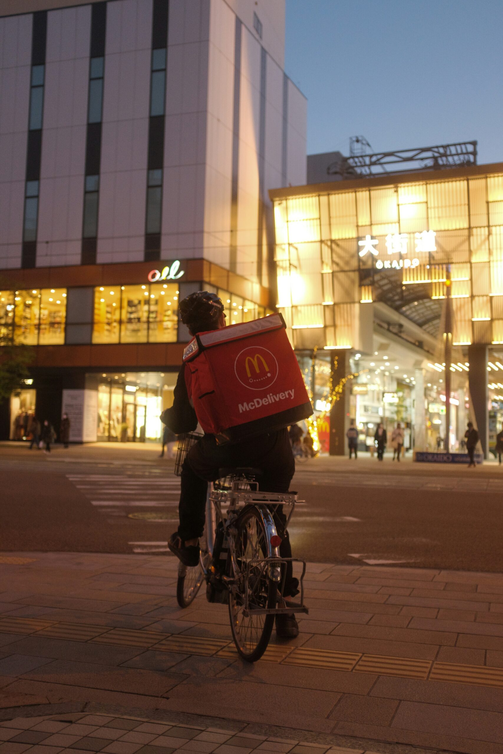 McDonald's Brighton reviews- a man delivering McDonald's in a city at night on his bike 