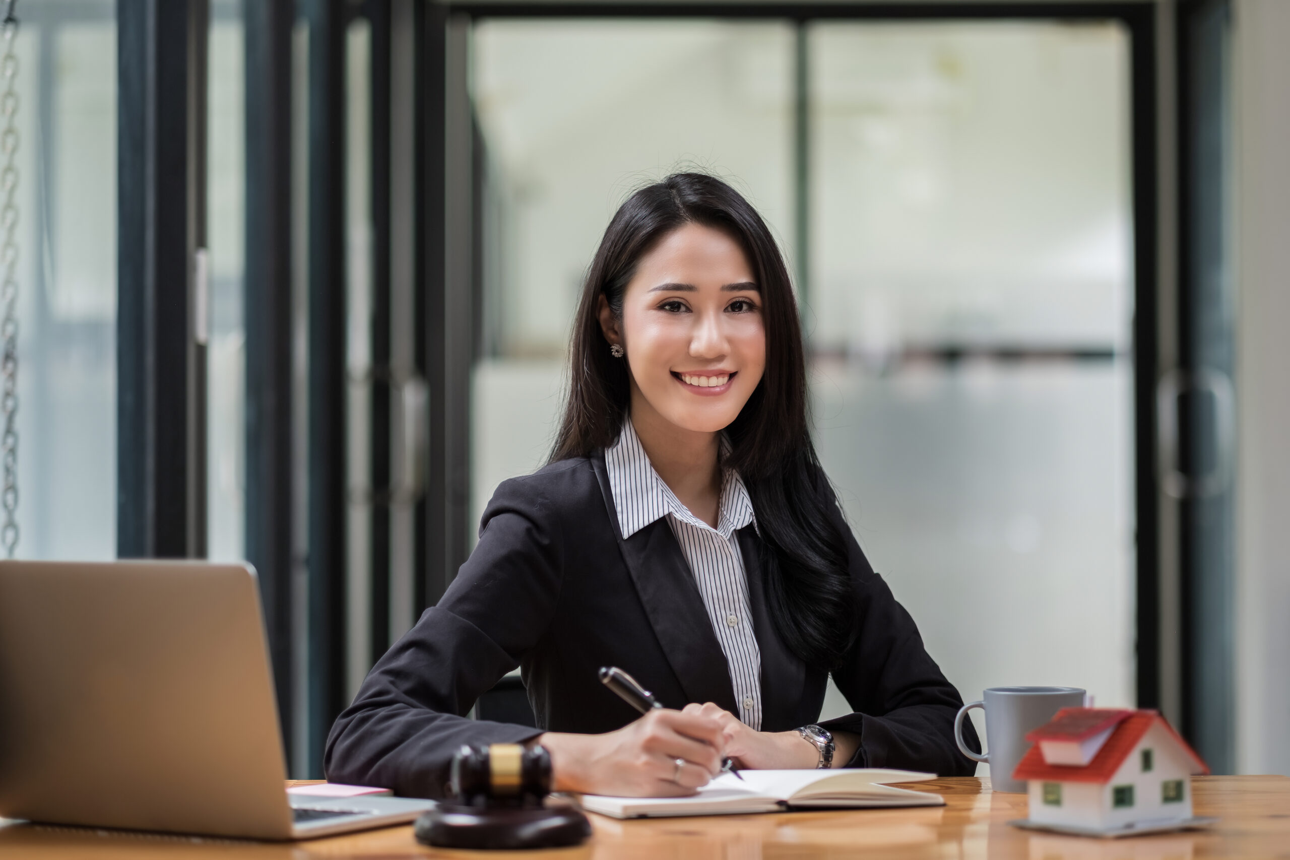Smiling Young Woman Working At Desk In Office