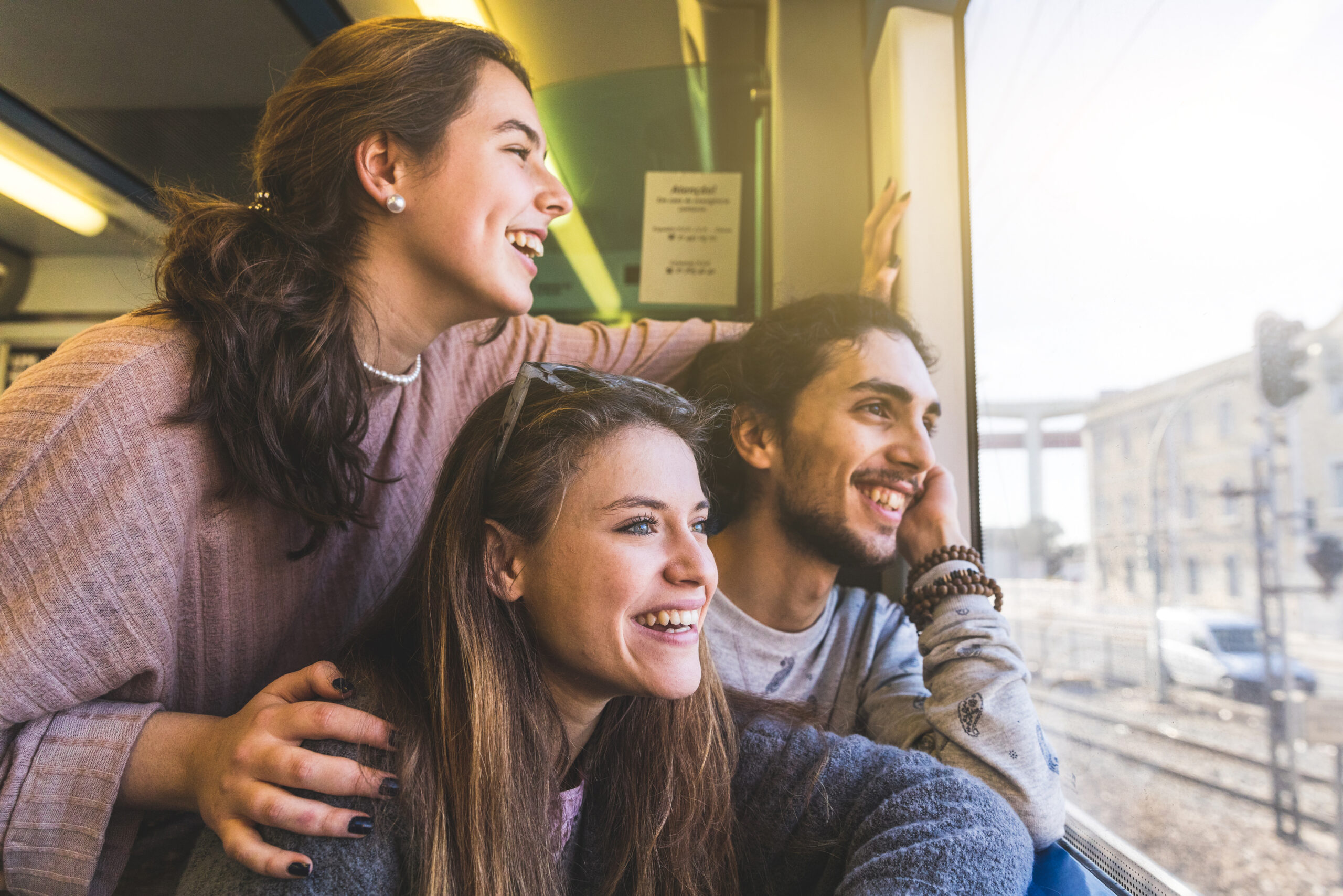 Three Friends Laughing Together On Train Ride 