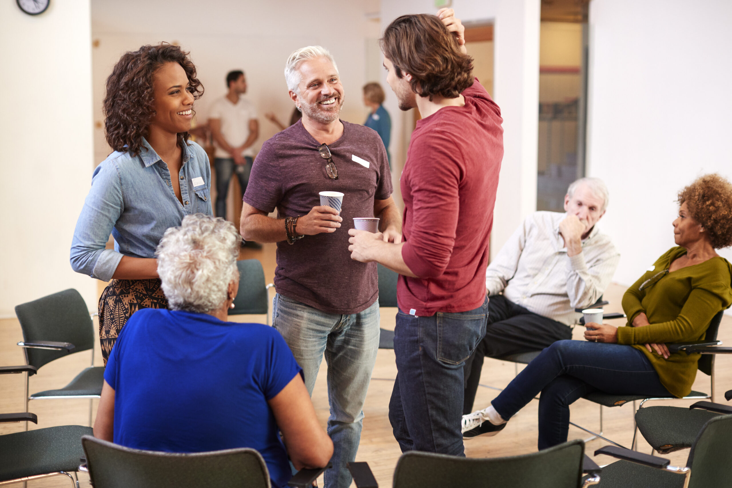 Group Of People Socializing After Meeting In Community Centre