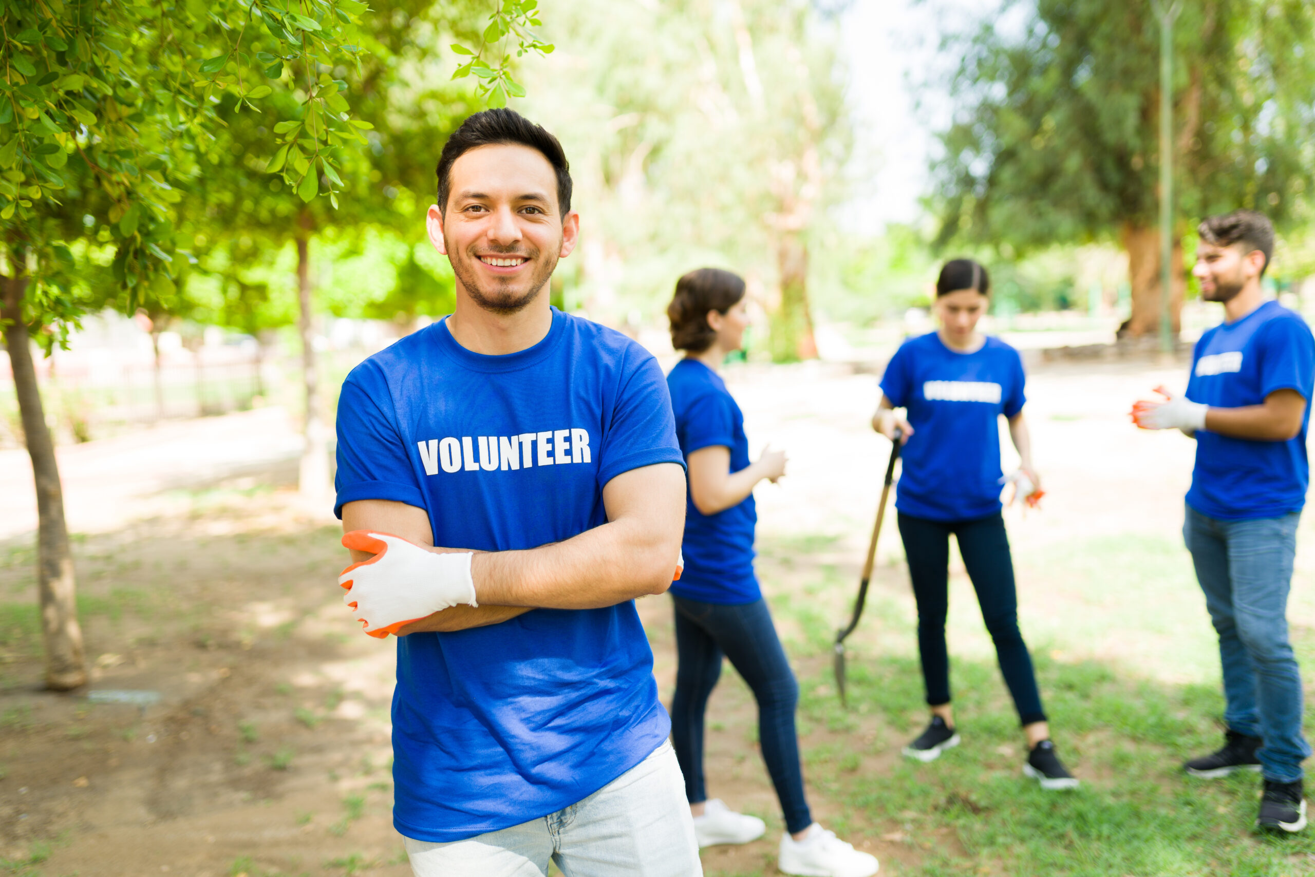 Smiling Volunteers Cleaning Up A Sunny Park