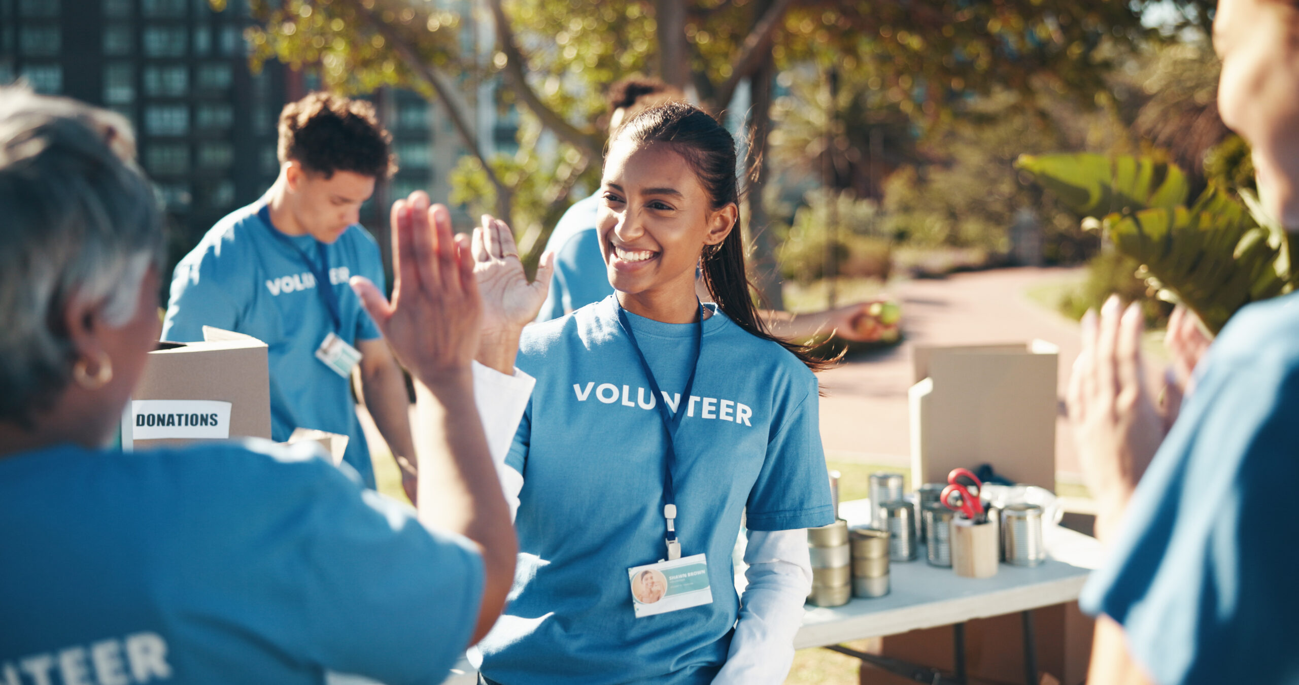 volunteers high fiving outdoors.