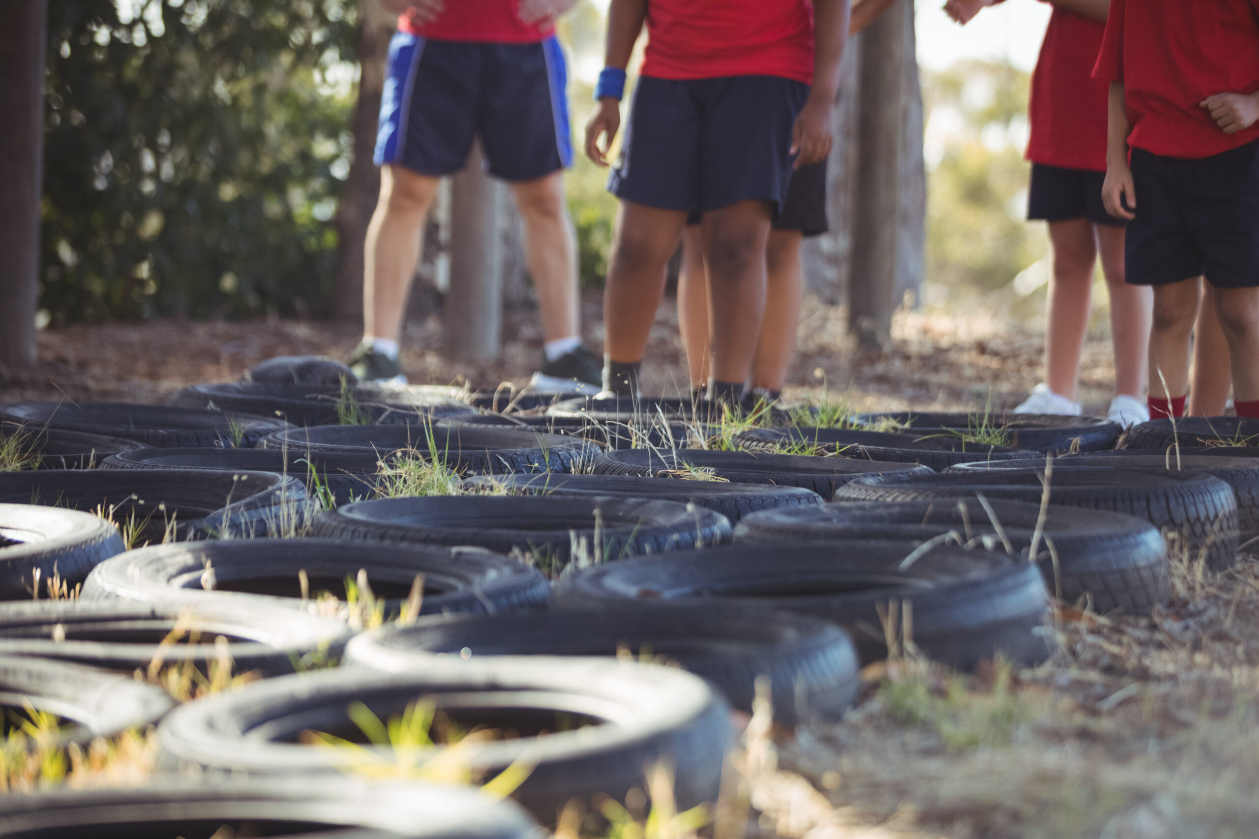 Kids Standing ready for an obstacle course with tyres