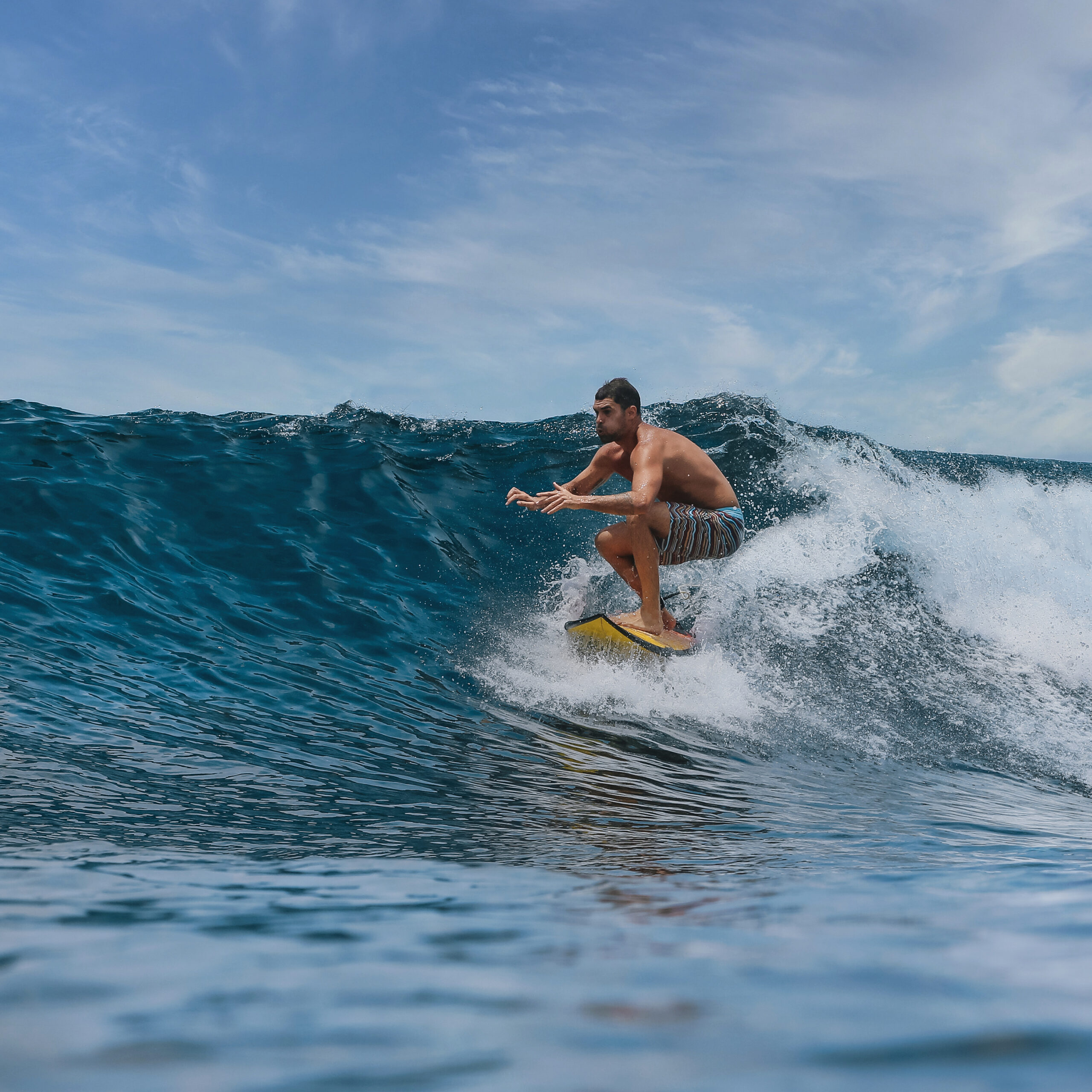 Male surfer on a blue wave at 