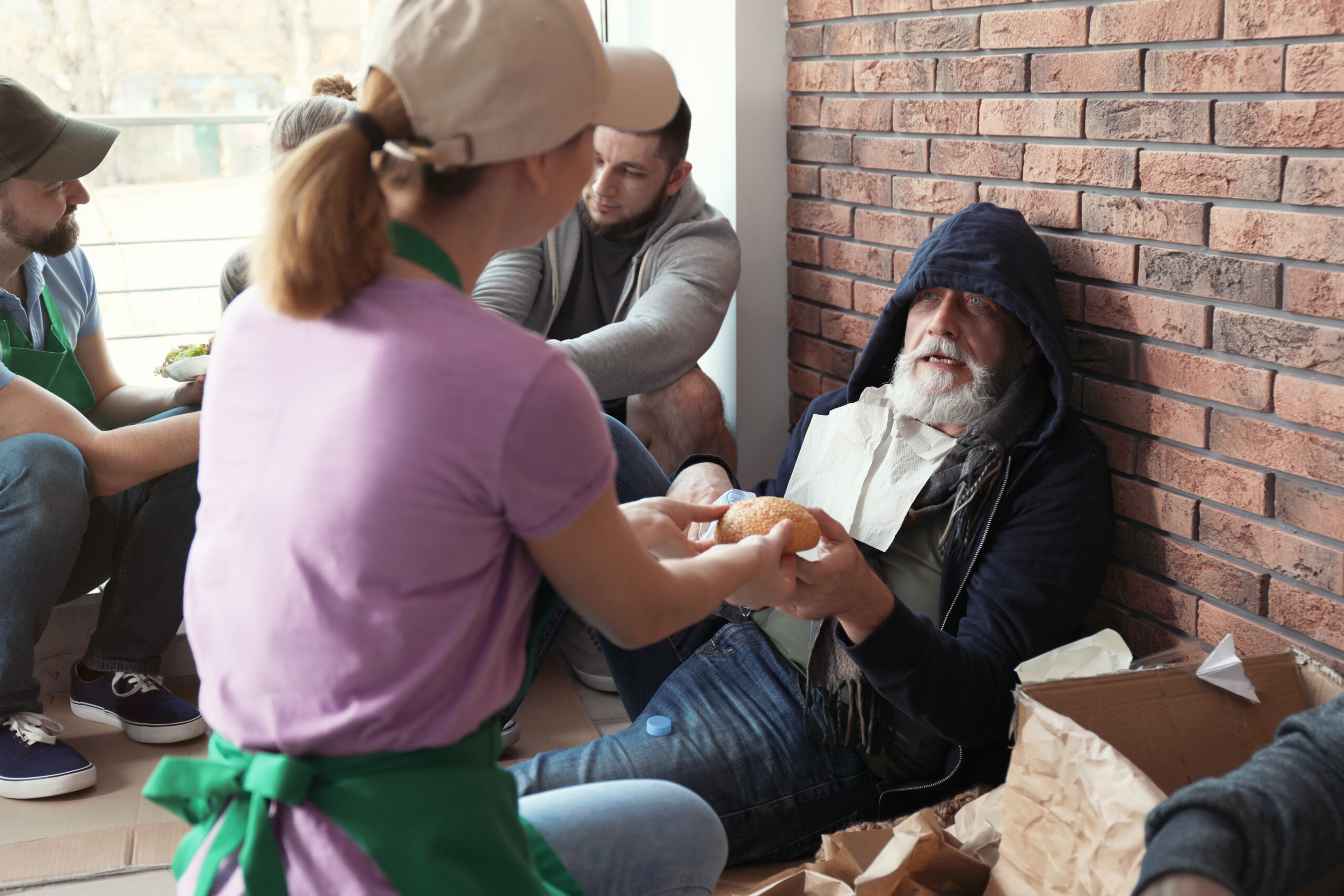 Brighton charities: Volunteer giving food to poor senior man