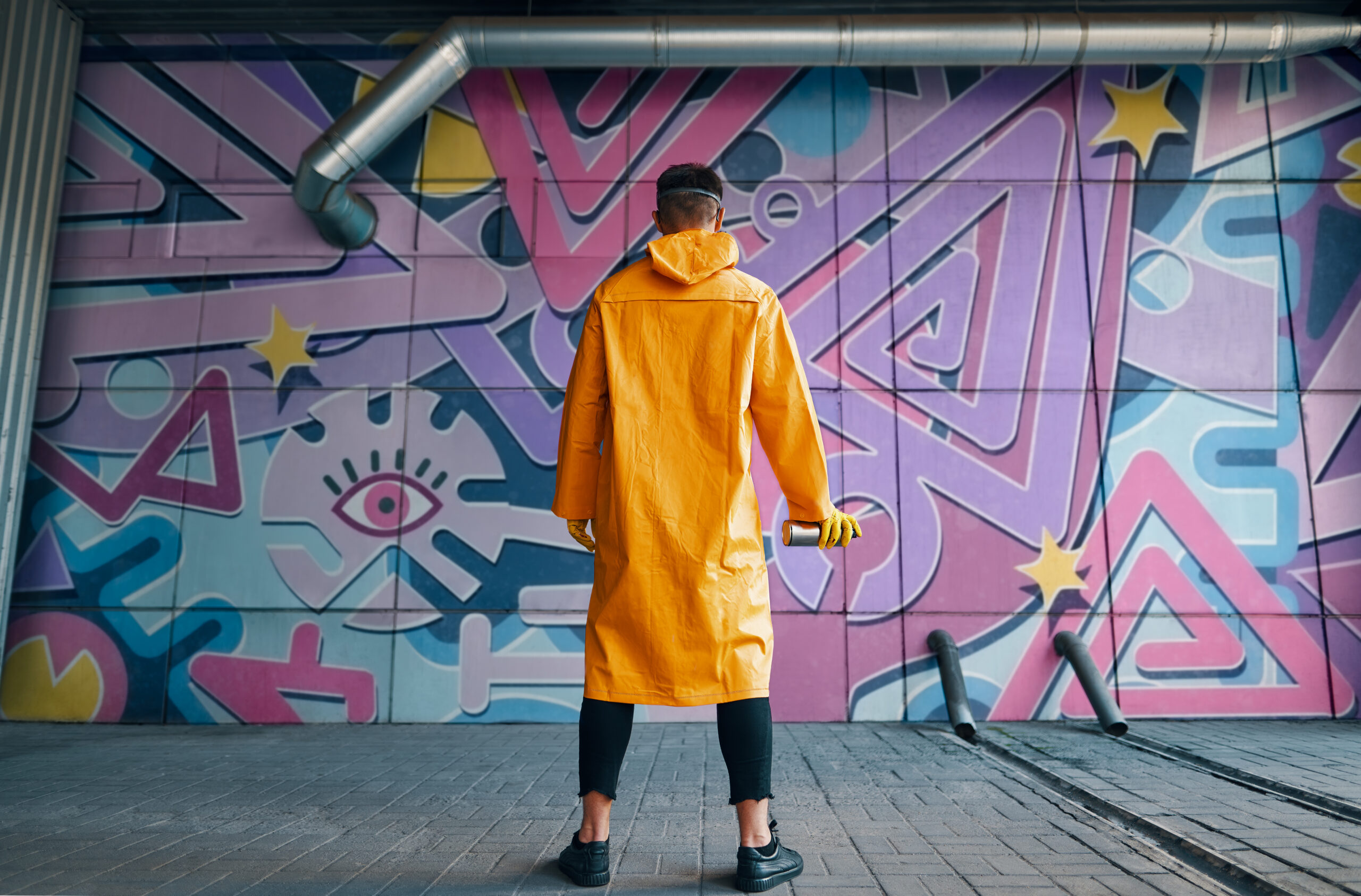 Back View Of Graffiti Painter Looking To The Wall