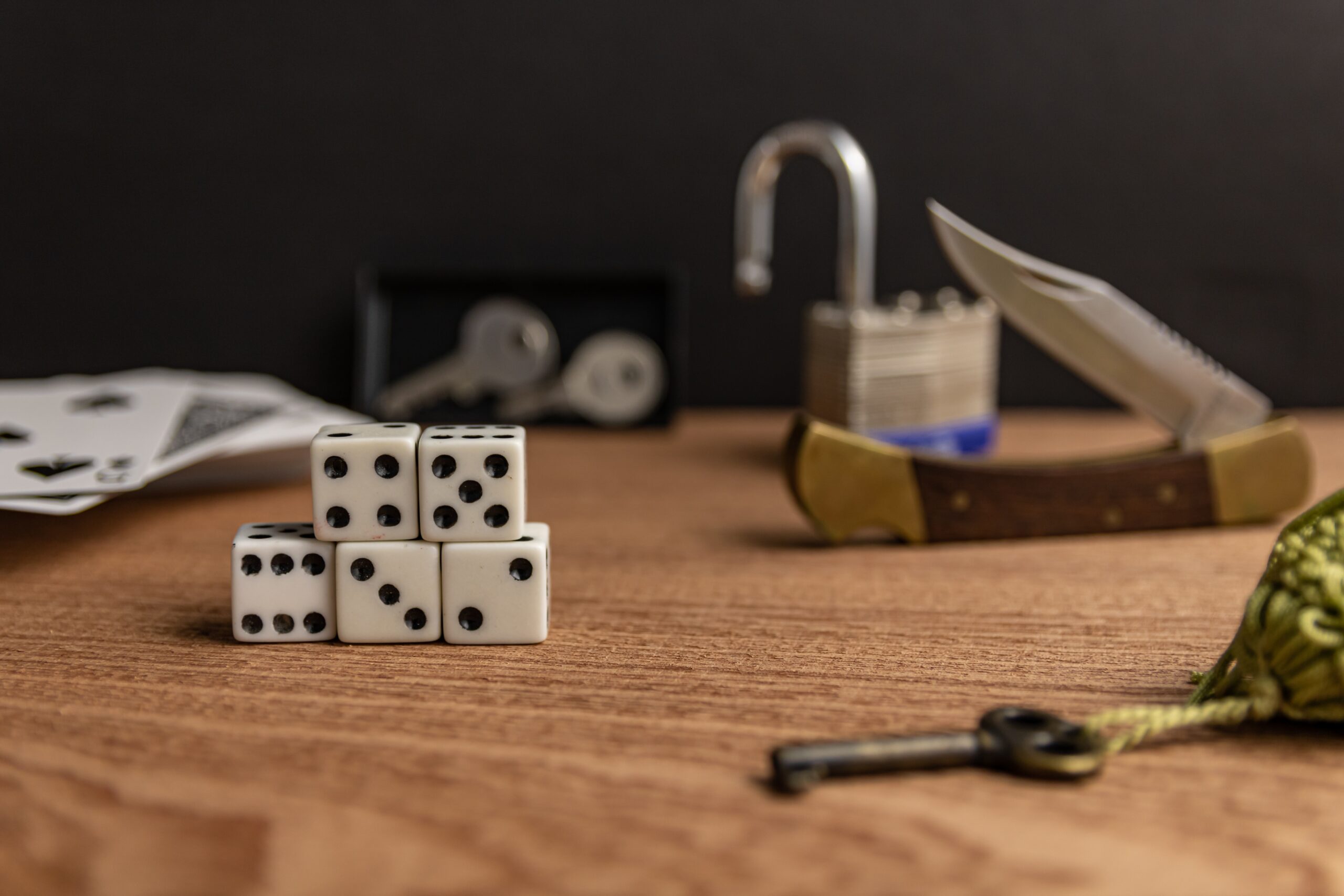 Dice, Knife, Lock and Keys on a Table
