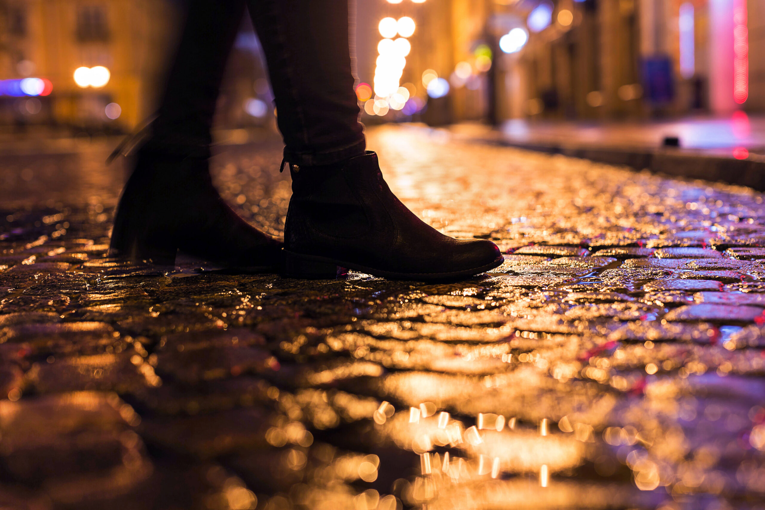 Woman in black shoes walking through the city street