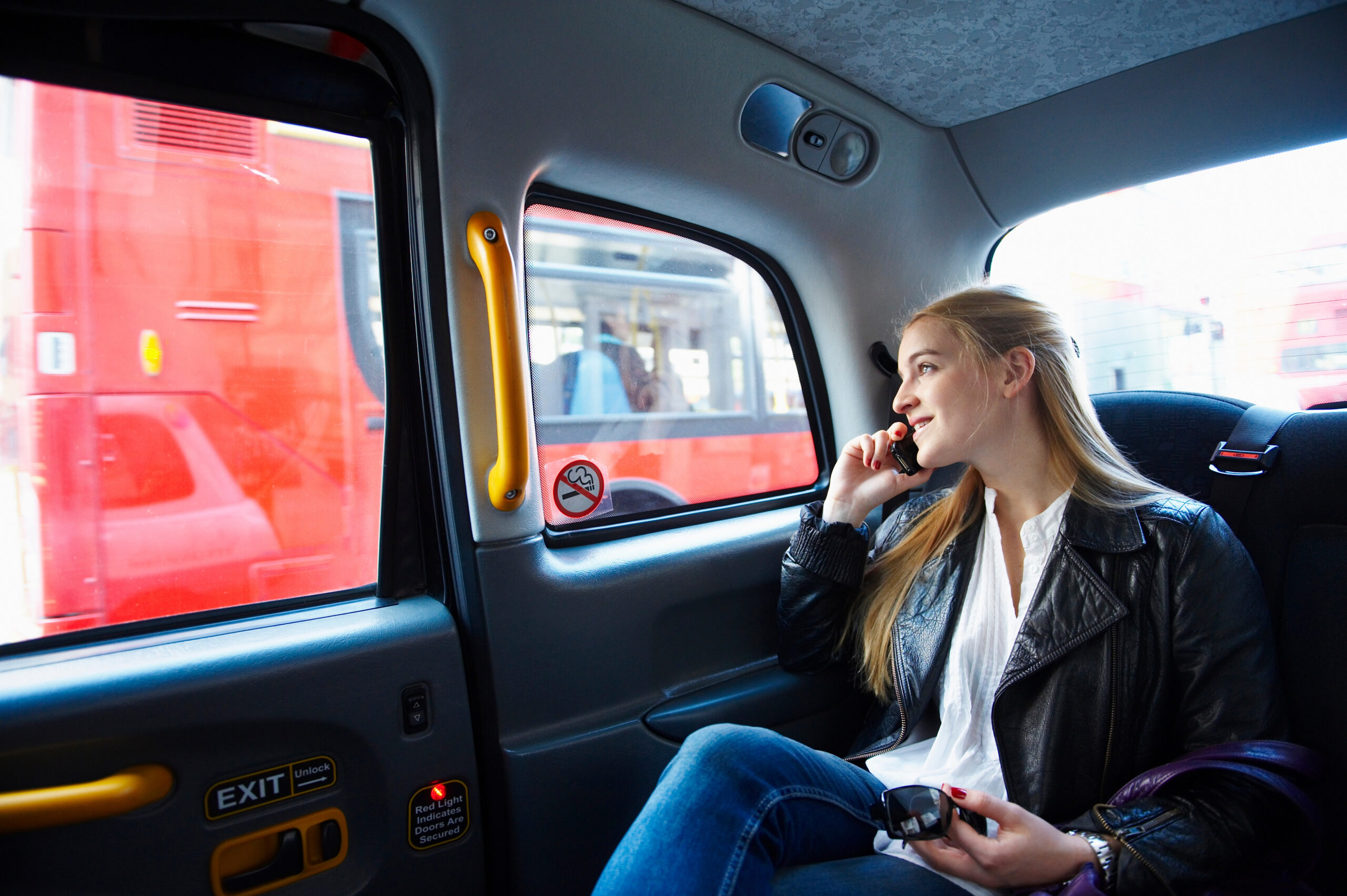 Woman Chatting On Mobile Phone Inside Taxi 