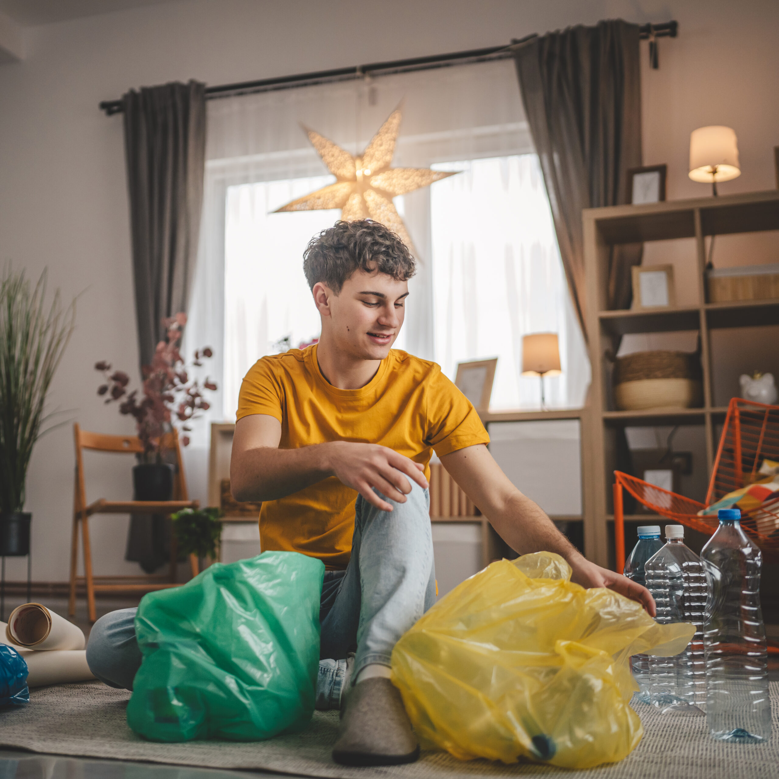 Young Man Sorting Plastic Bottles And Recycling in Brighton