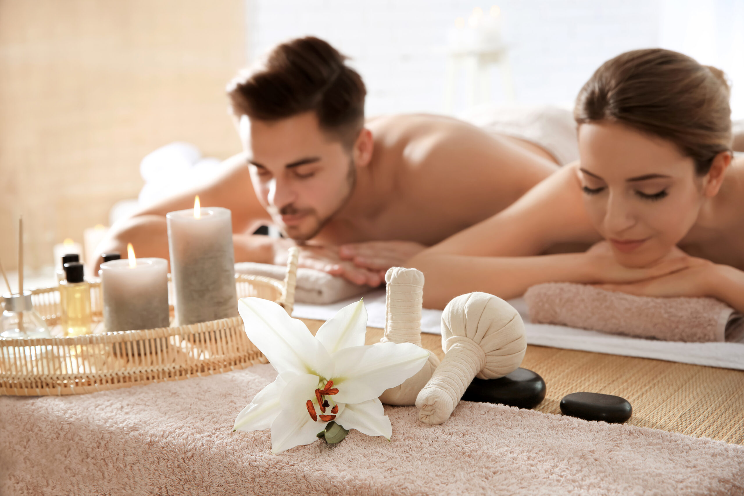 Young couple with spa essentials in wellness centre