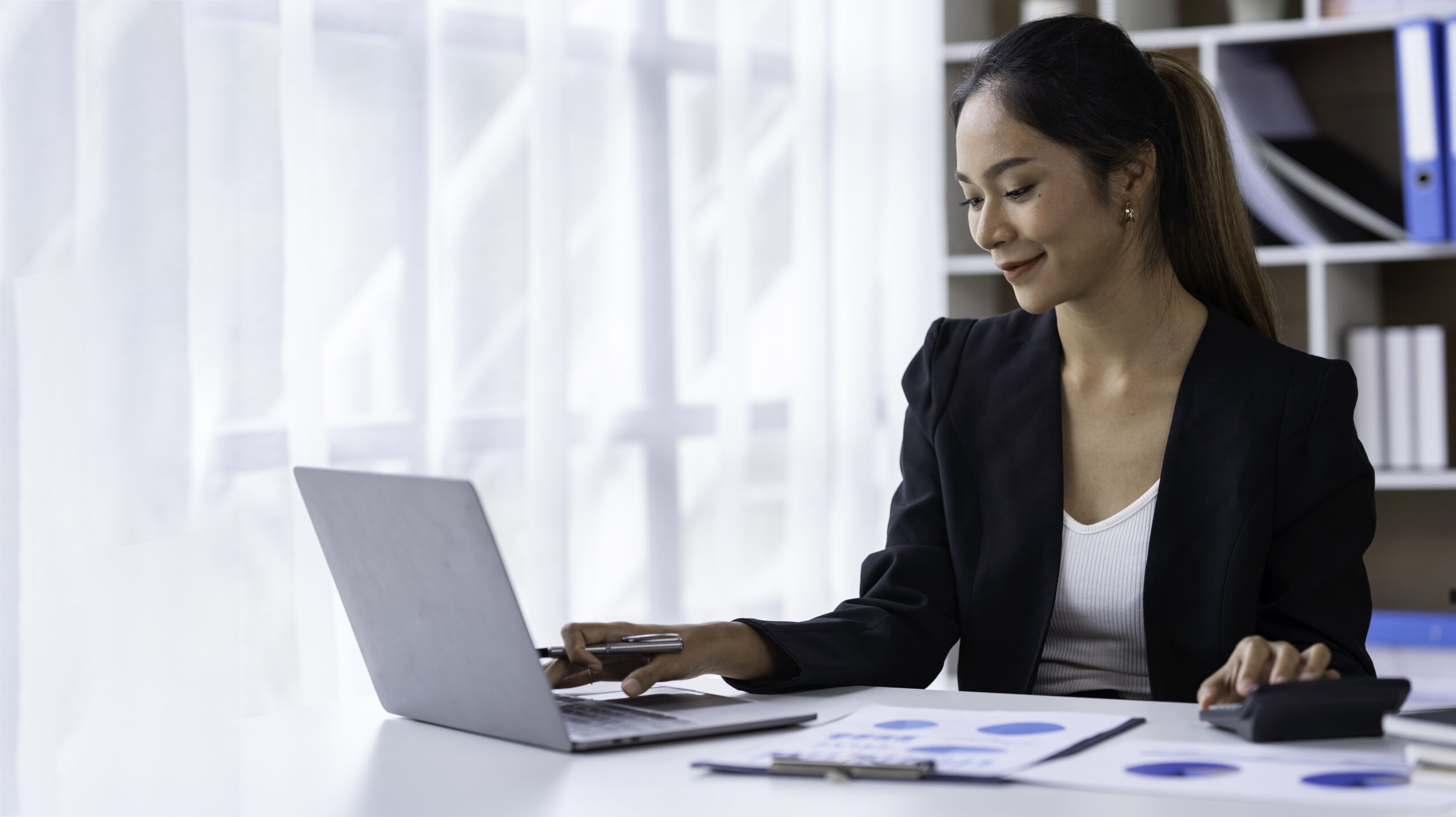 A smiling accountant looking at their laptop