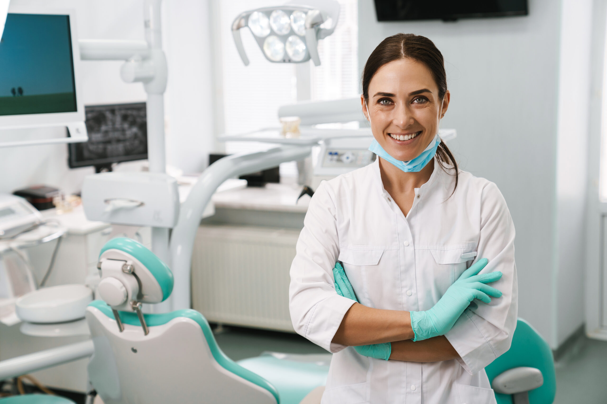 Dentist woman smiling while standing in dental clinic