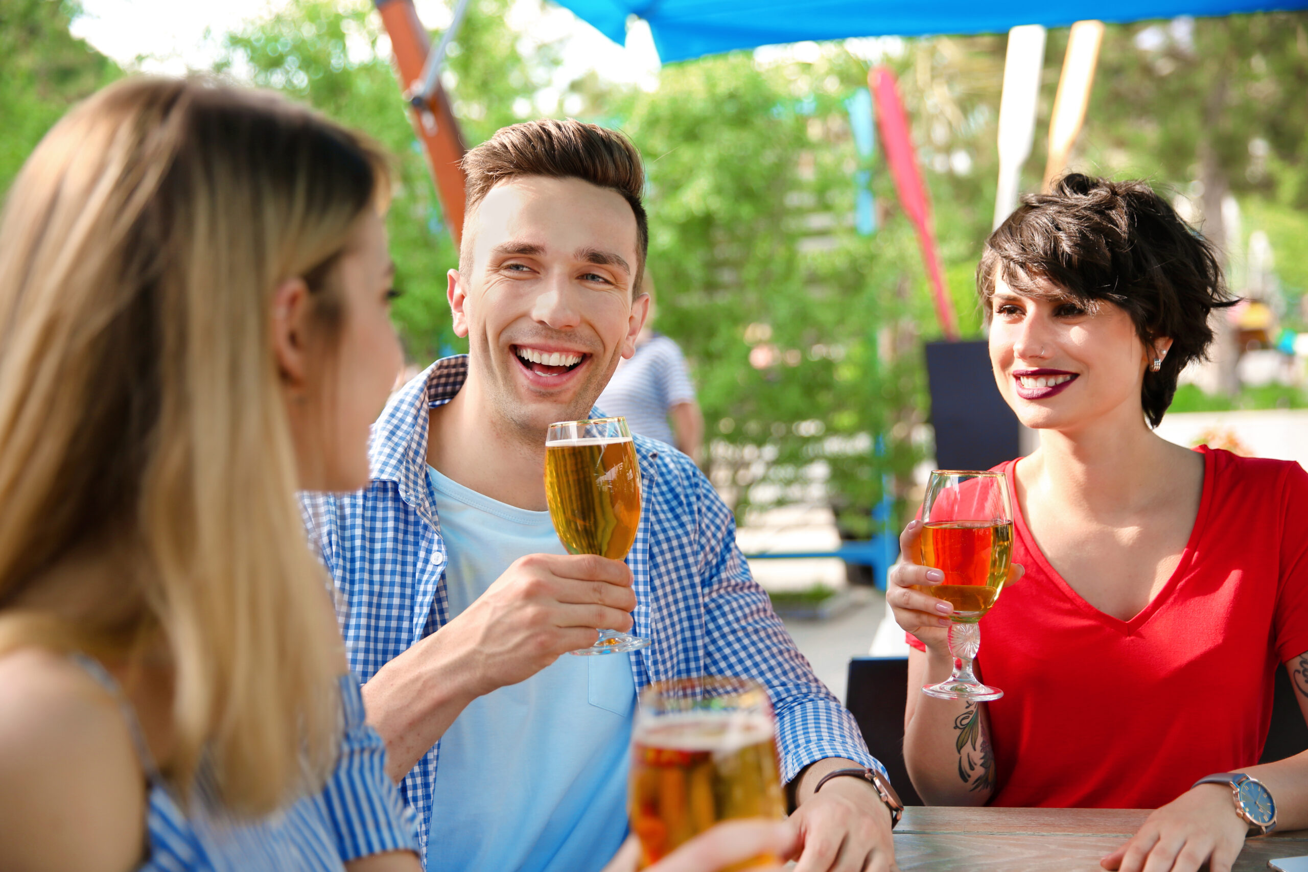 Young people with glasses of cold beer at table