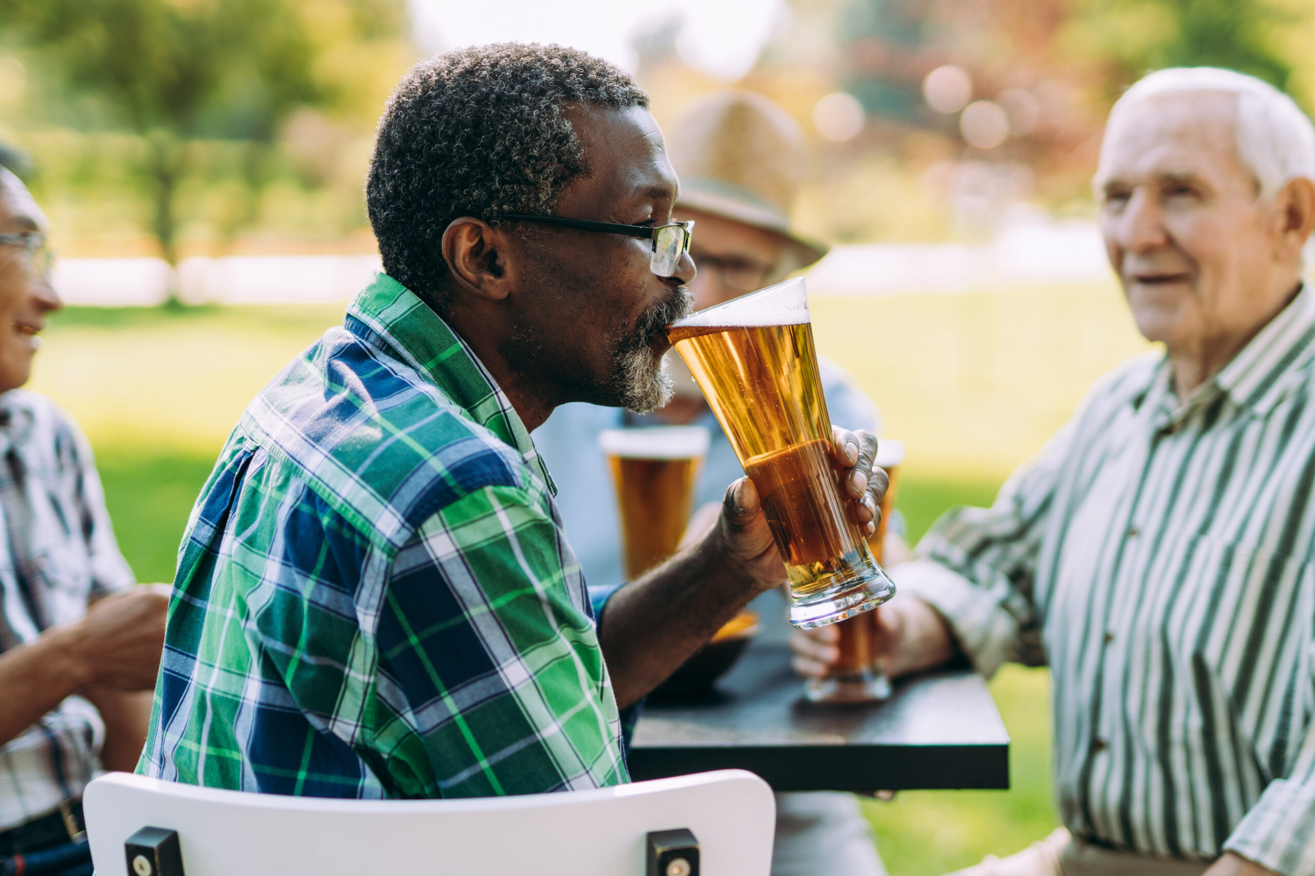 Group Of Senior Friends Drinking A Beer in a park