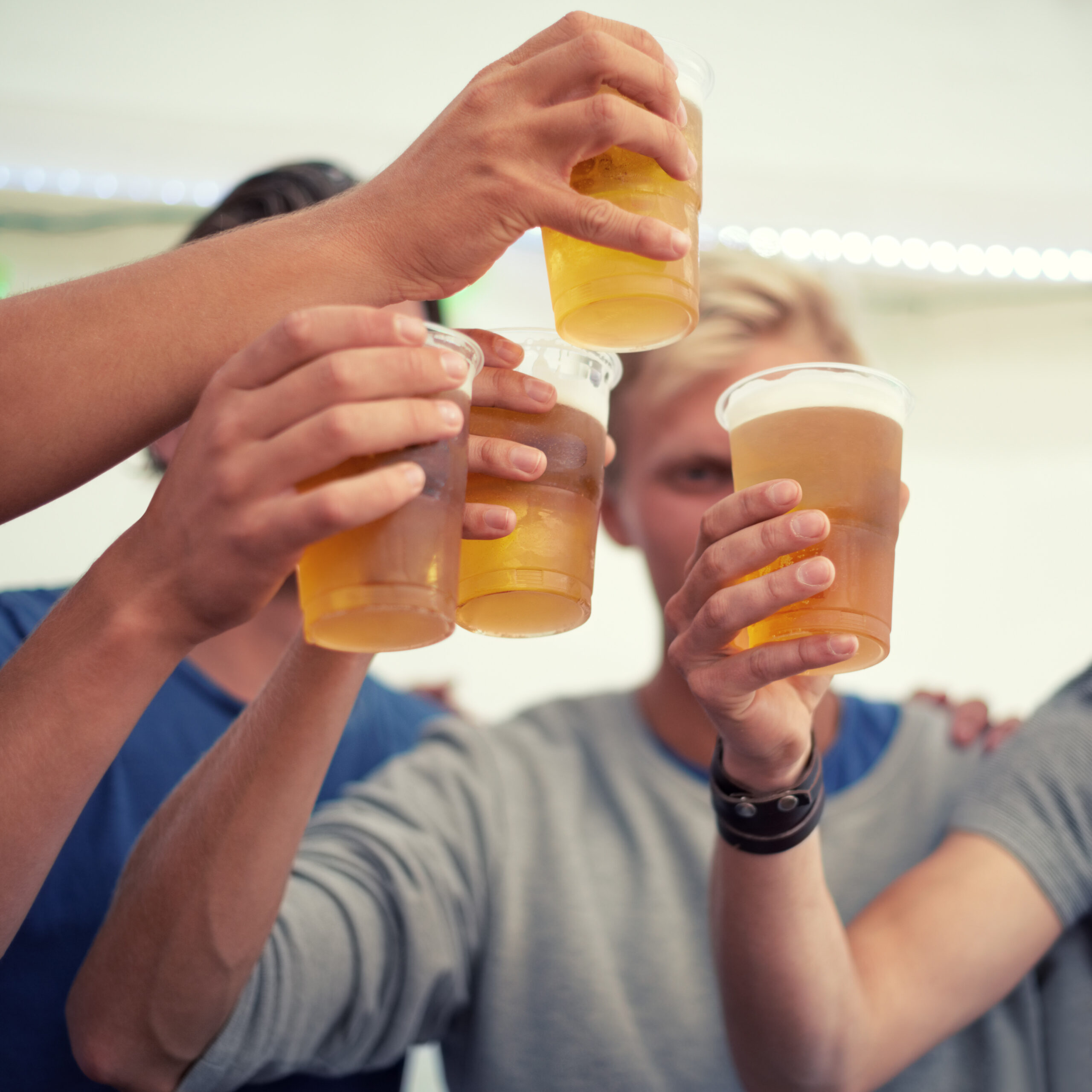 Friends Toasting with Beer in Plastic Glasses