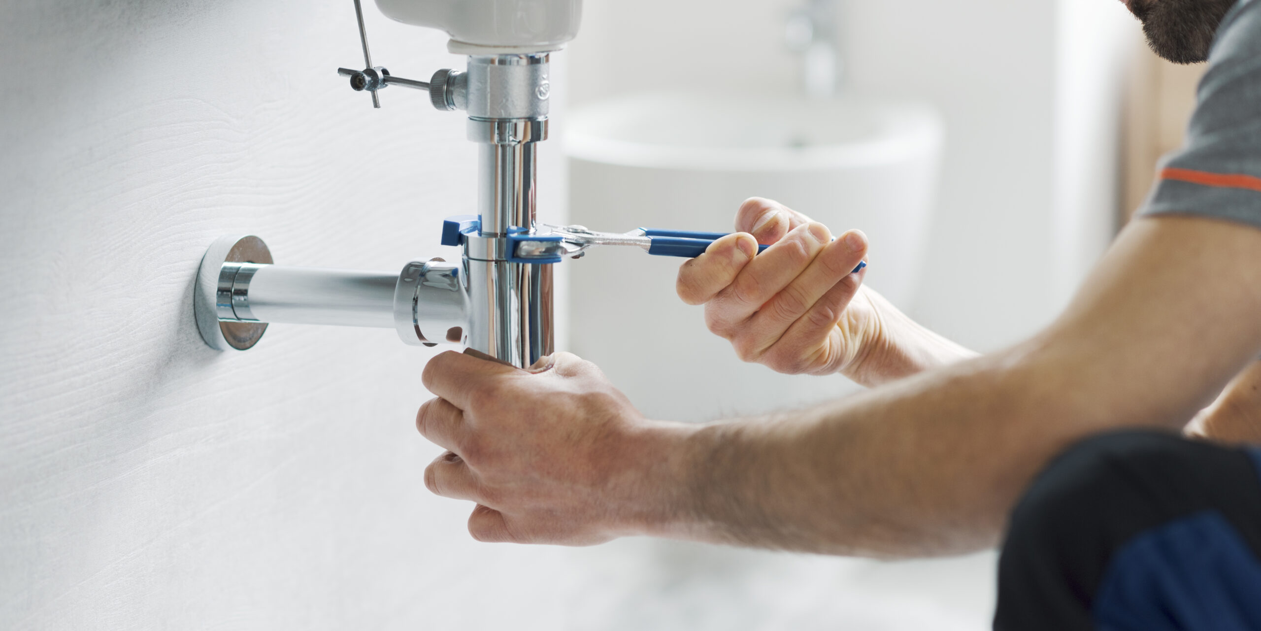 Plumber Repairs Sink Drain Under The Bathroom Sink
