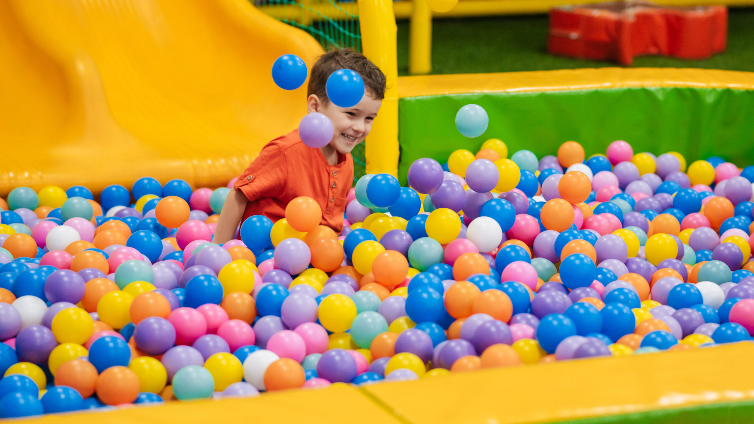 A Happy child playing In a ball pit
