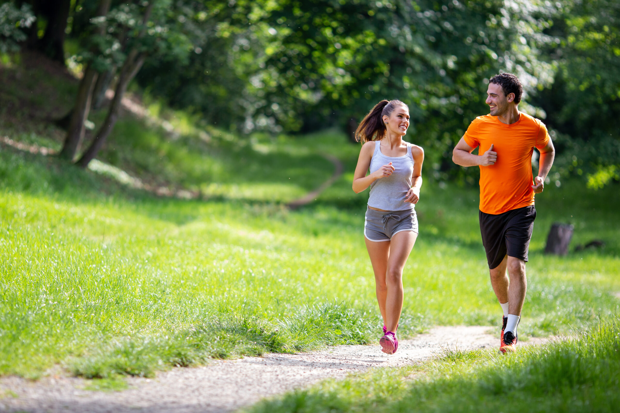 Happy young fit people running together outdoors.