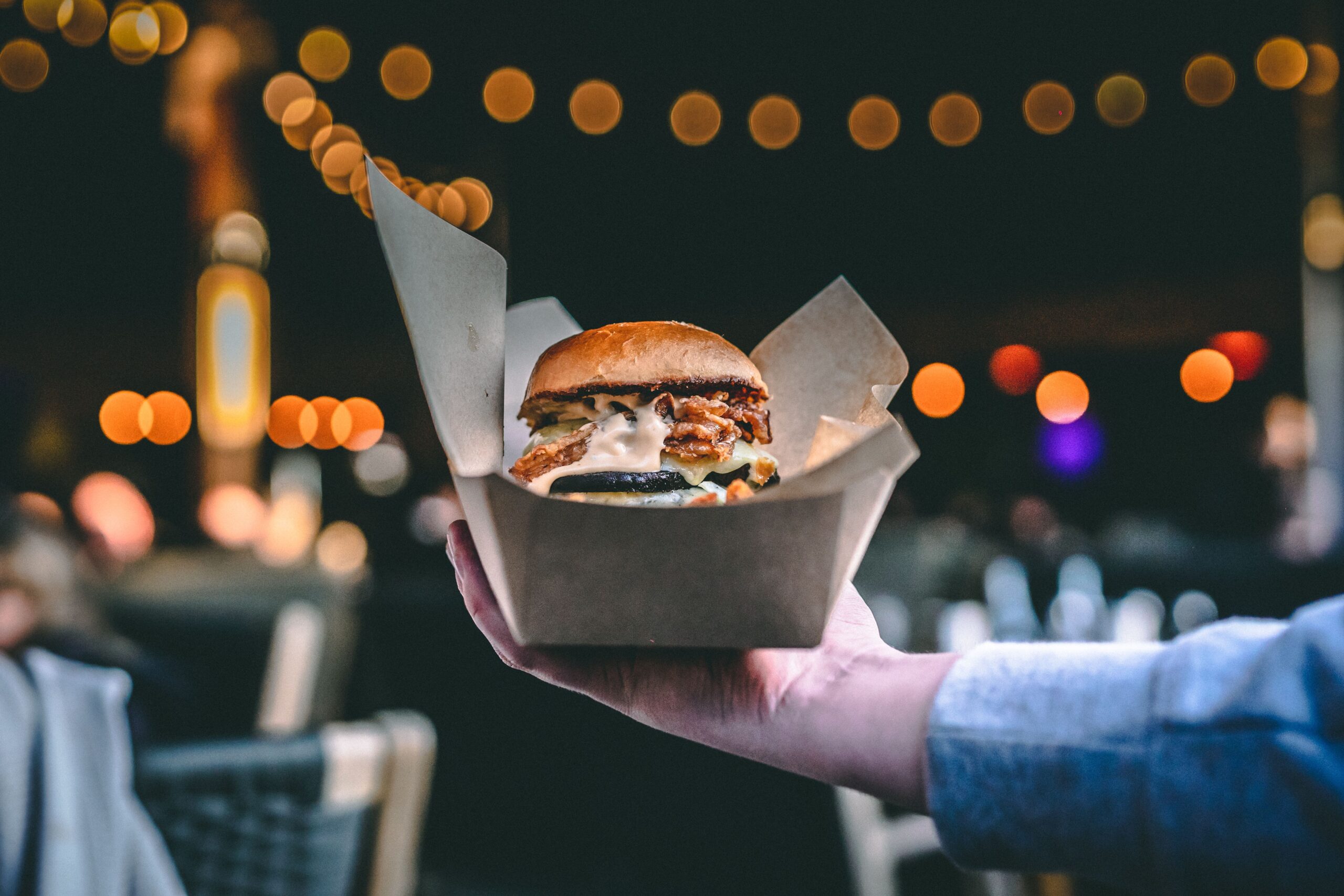 Late night food in Brighton: Delicious Burger With Sauce Held Up Outdoors 