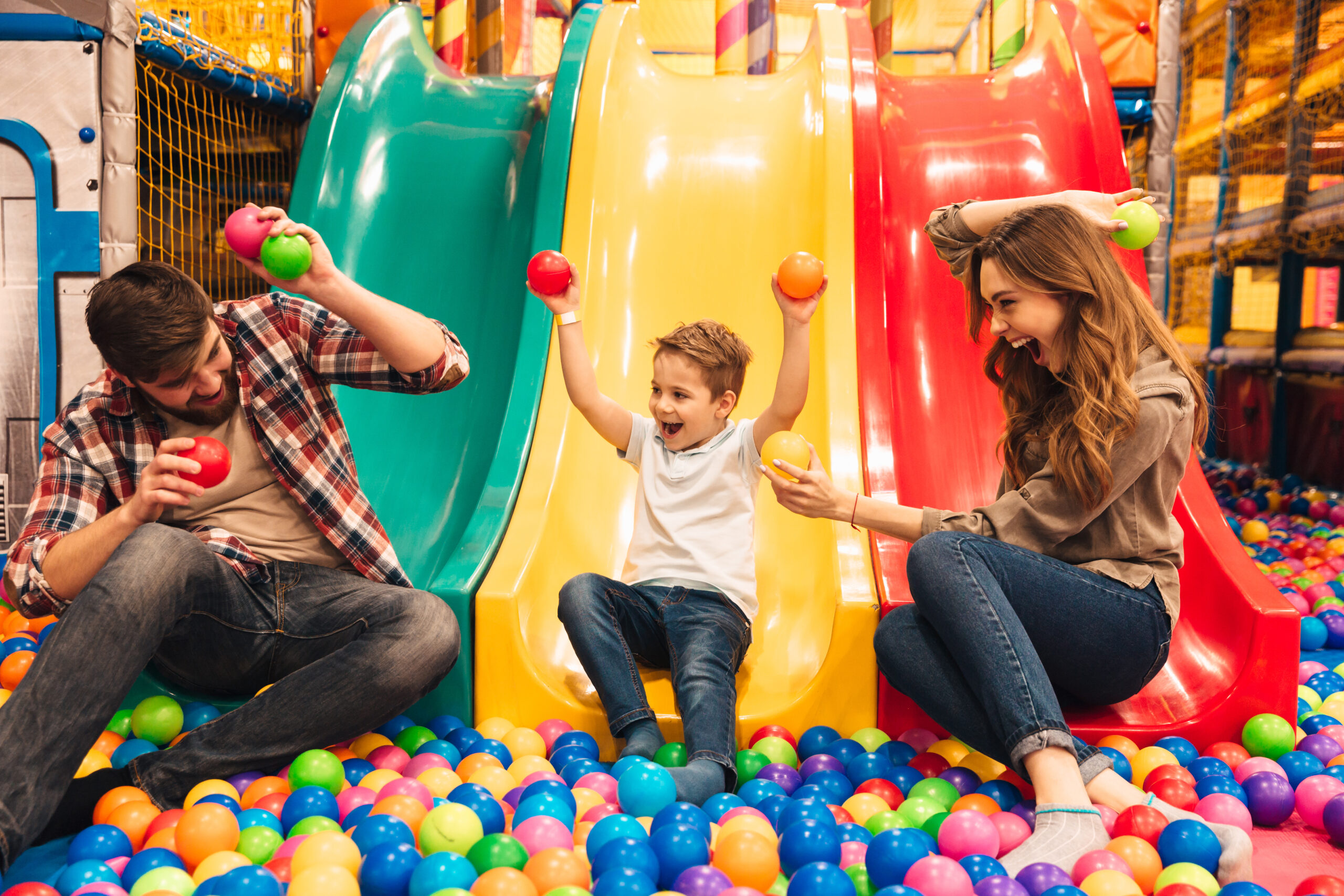 Soft play in Brighton: Excited Little Boy Playing On A Slide With His Parents