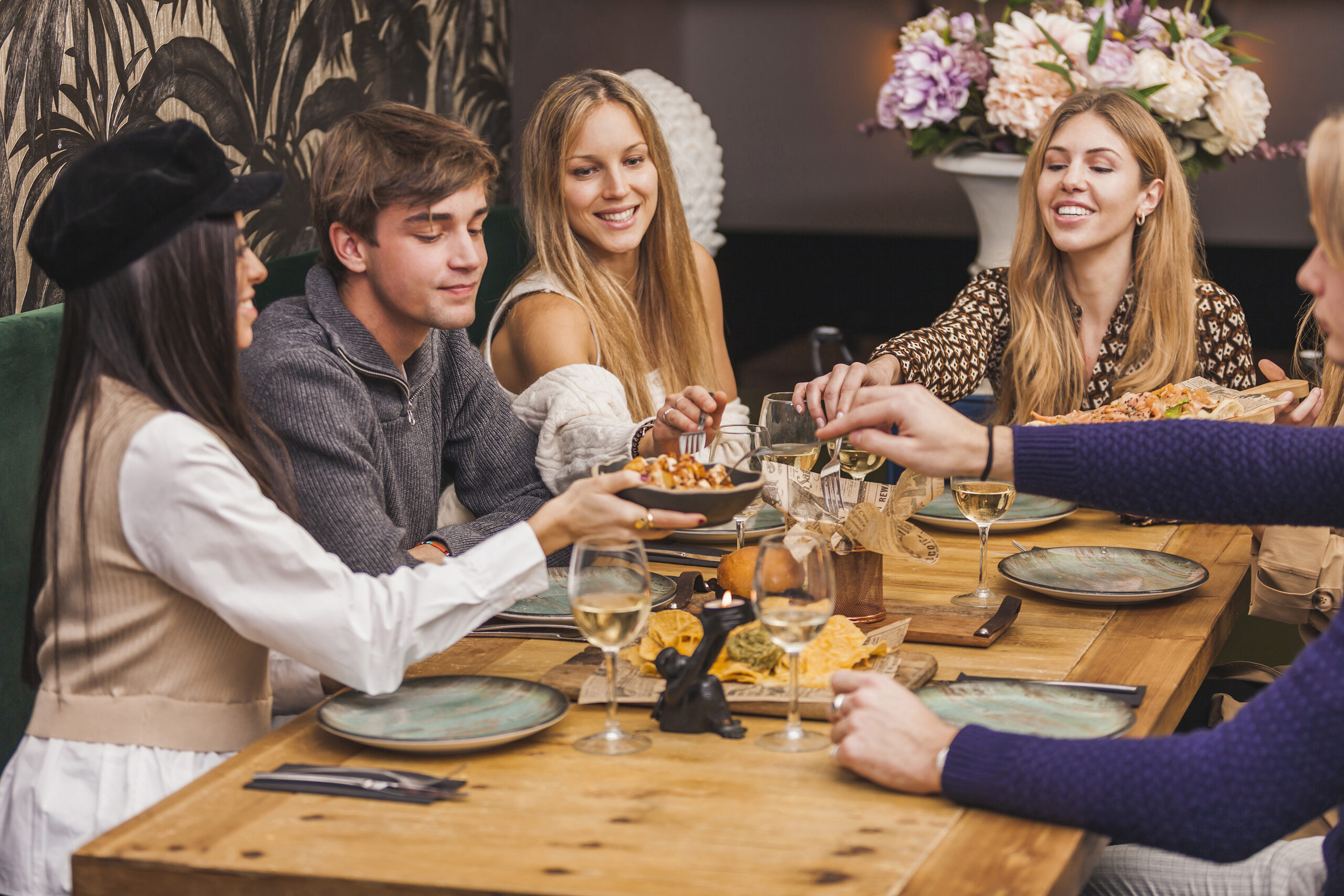 Friends Share Appetizers At a Table With Drinks 