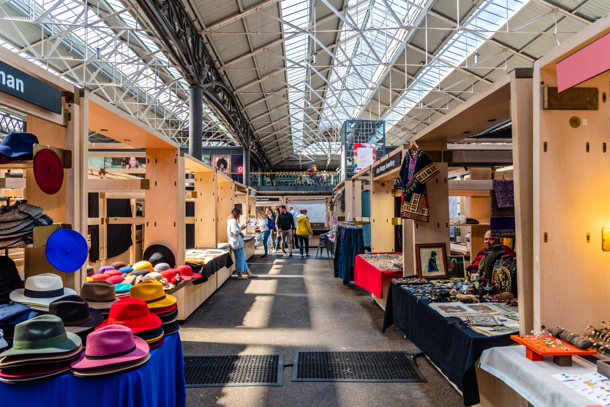 Indoor Market Scene With Customers And Vendor Stalls