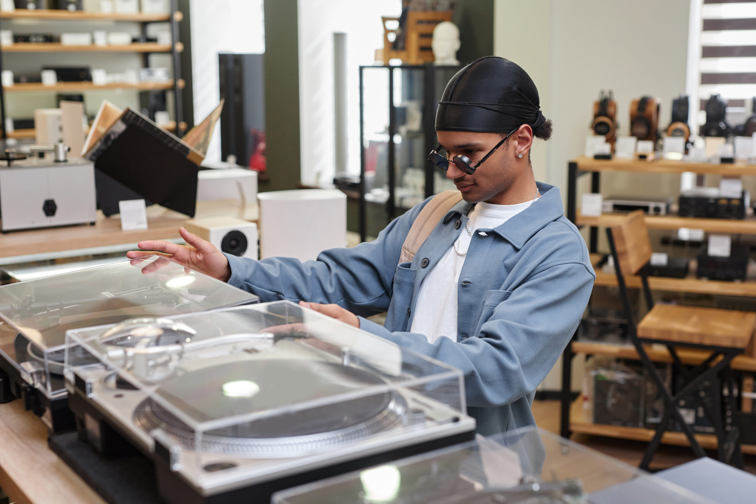 Young Man Choosing a Record Player In a record store