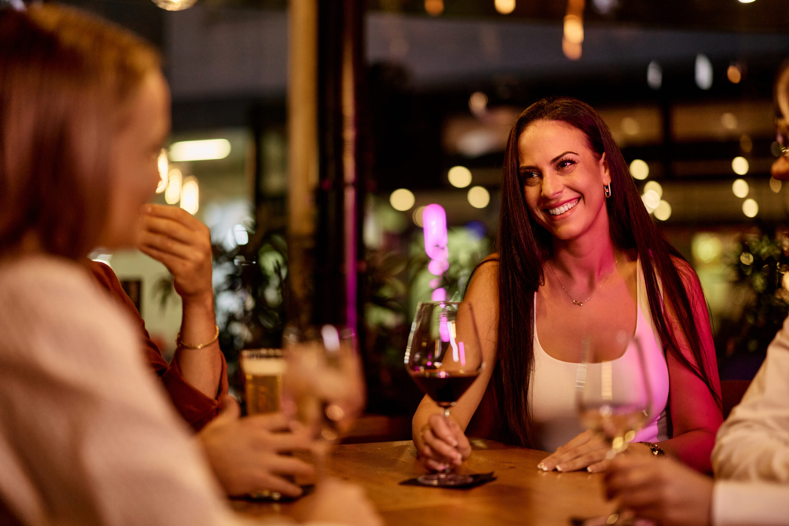 Friends sharing a joyful evening with drinks at a casual outdoor social setting at the weekend in Brighton