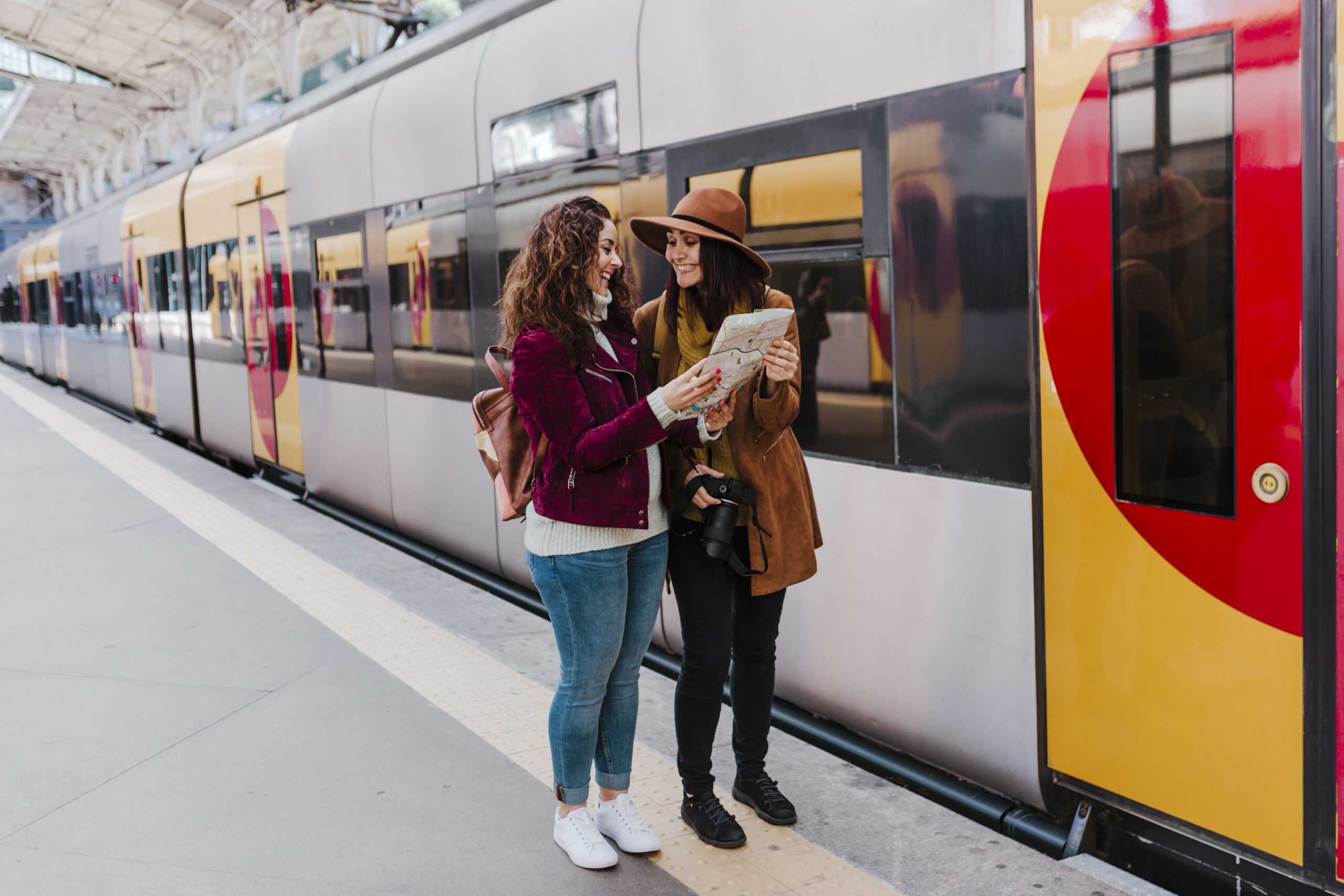 Two Women Reviewing Map At A Train Station