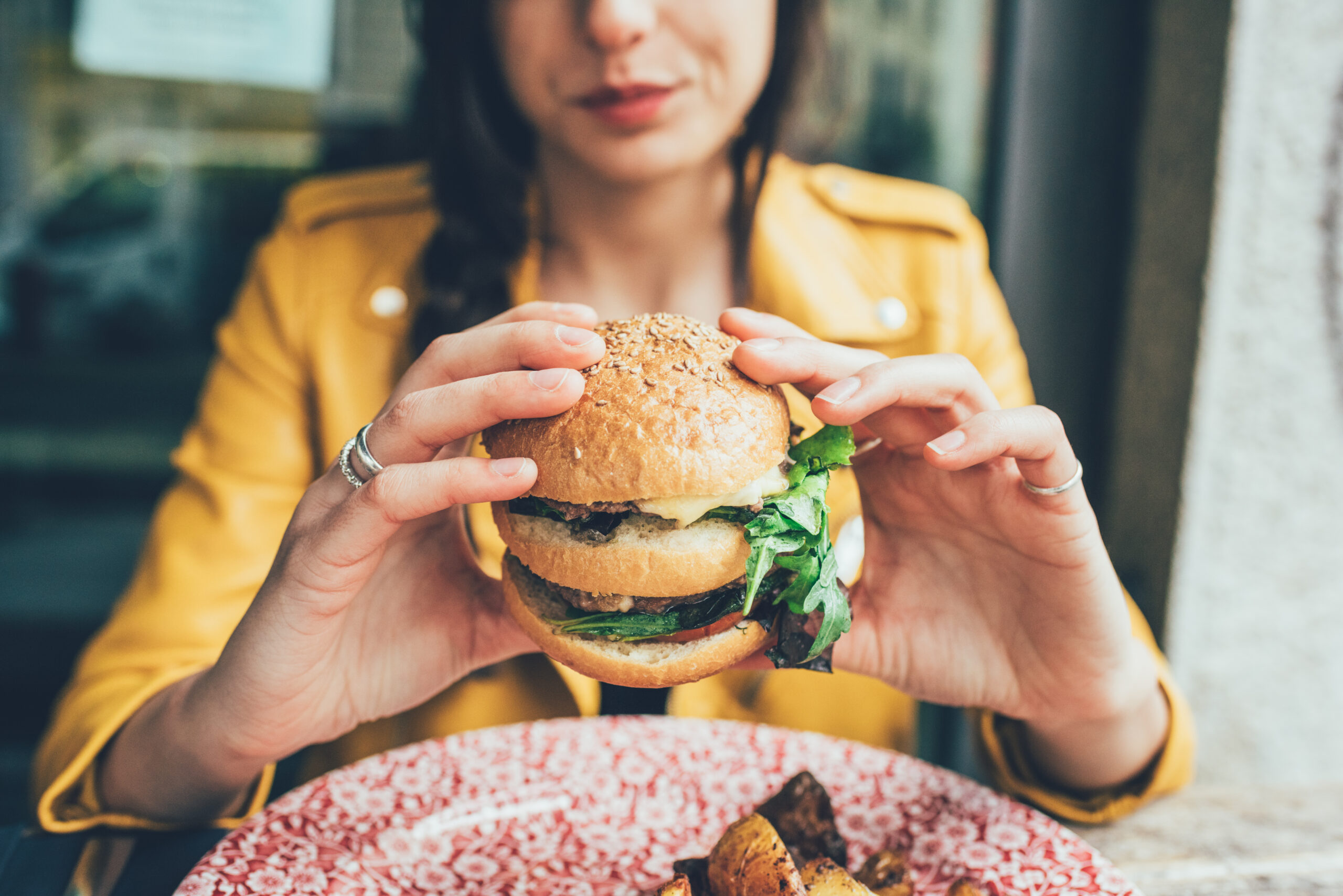 A woman eating a burger in Kemptown