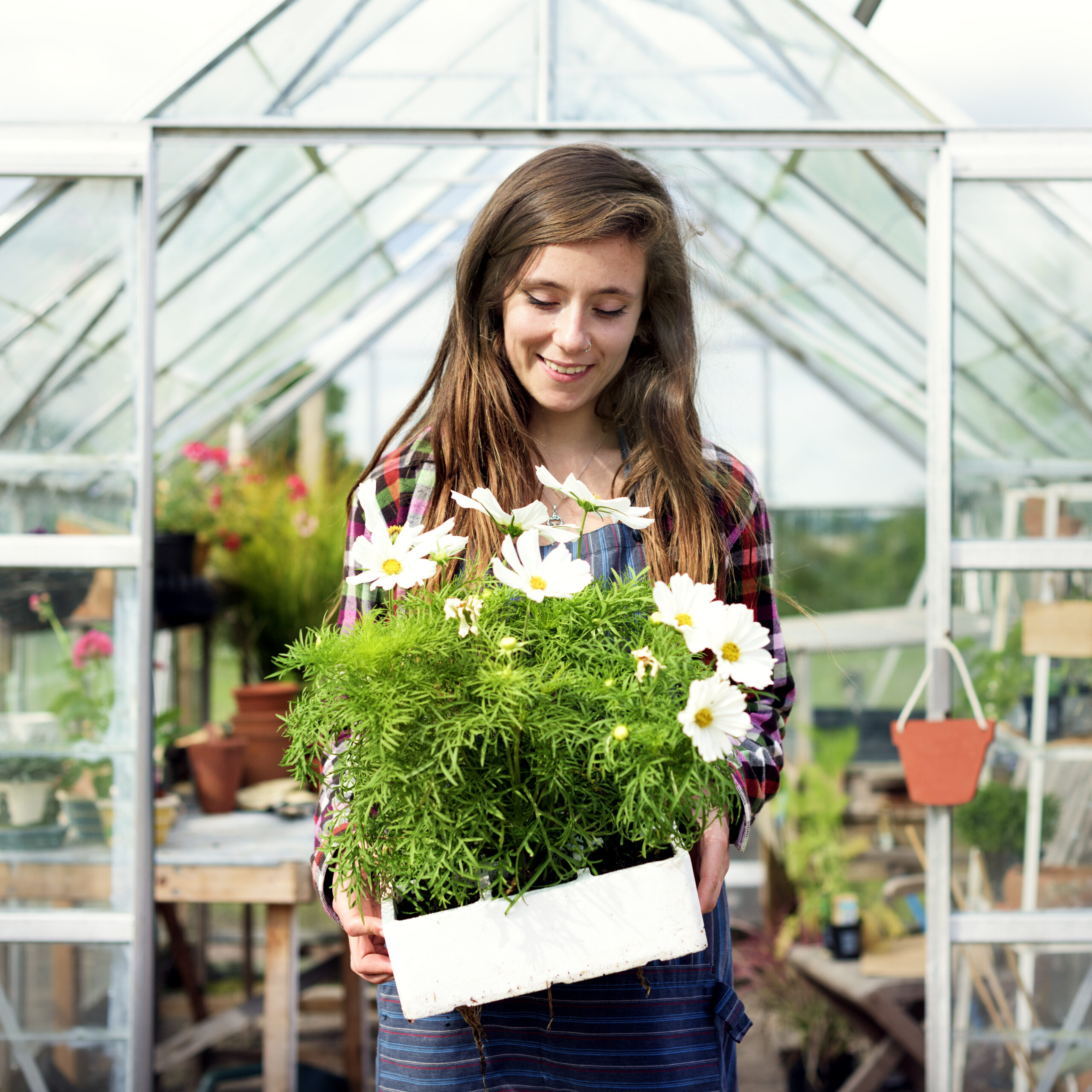 Young woman holding a flower pot at one of the garden centres in Brighton