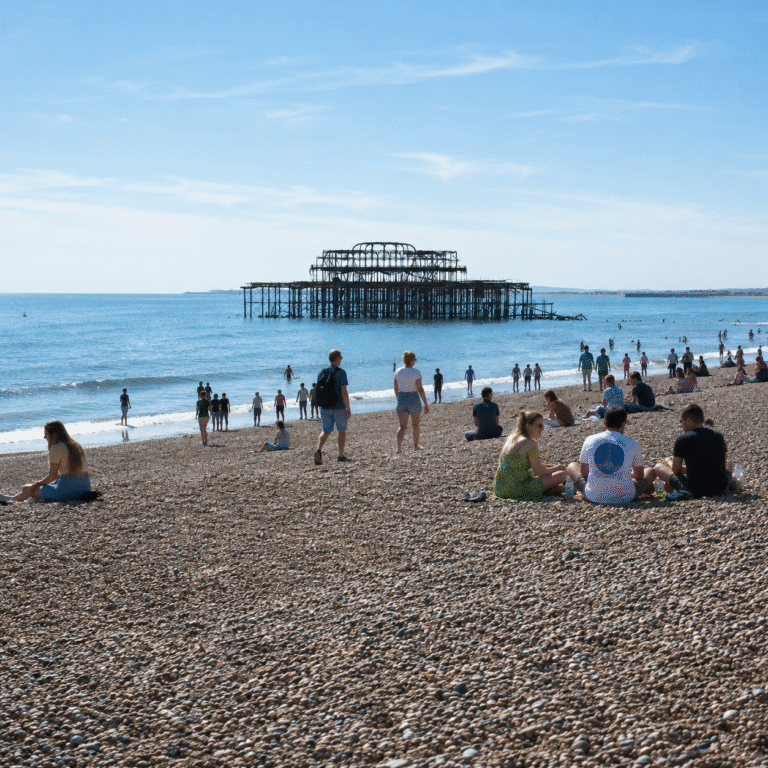 People on Brighton beach overlooking the west pier