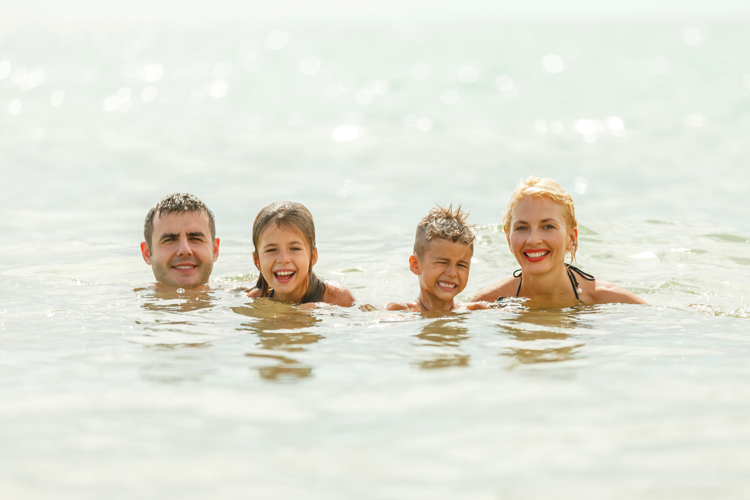 Happy family swimming in the sea together