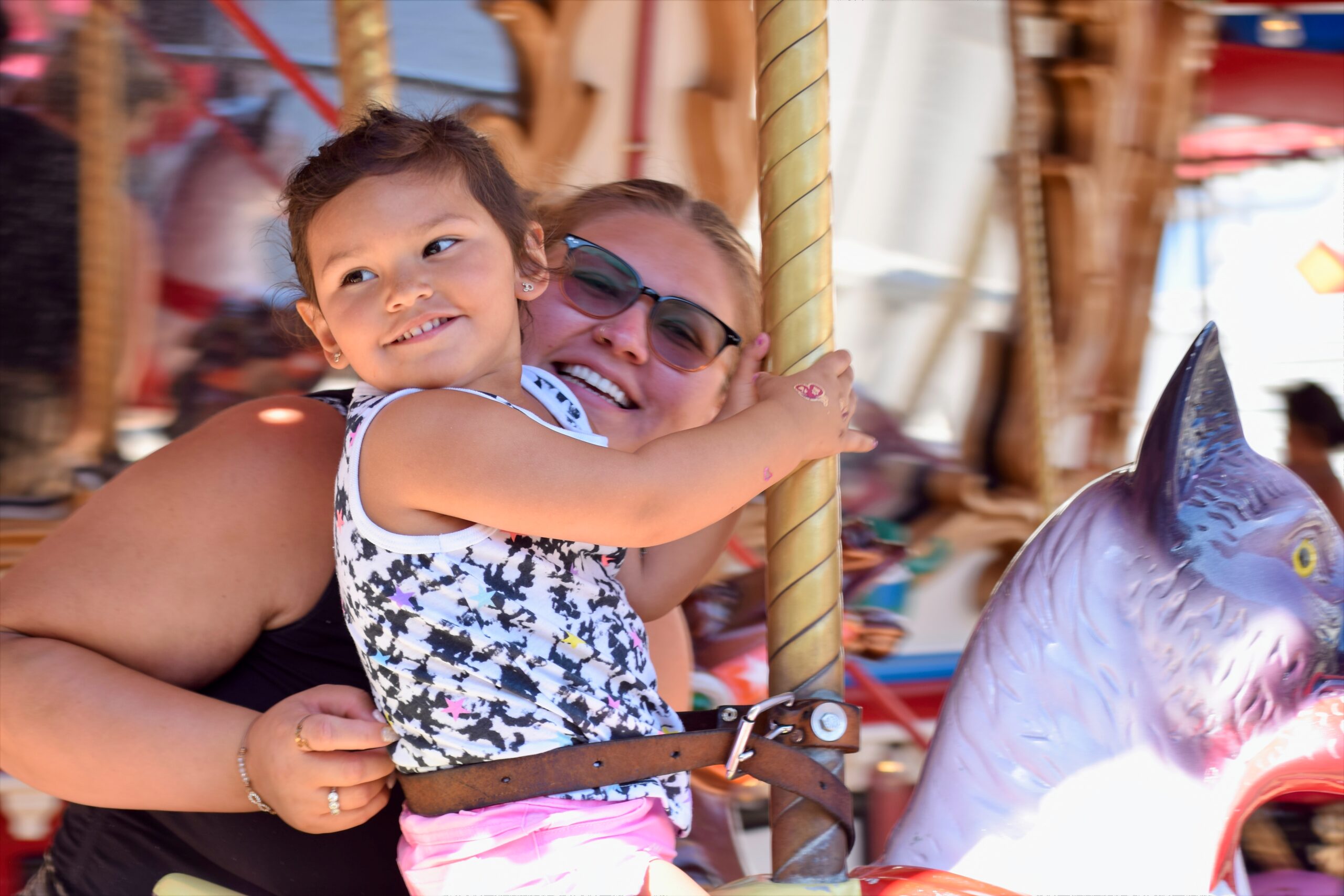 Child And Adult Riding The Carousel Together