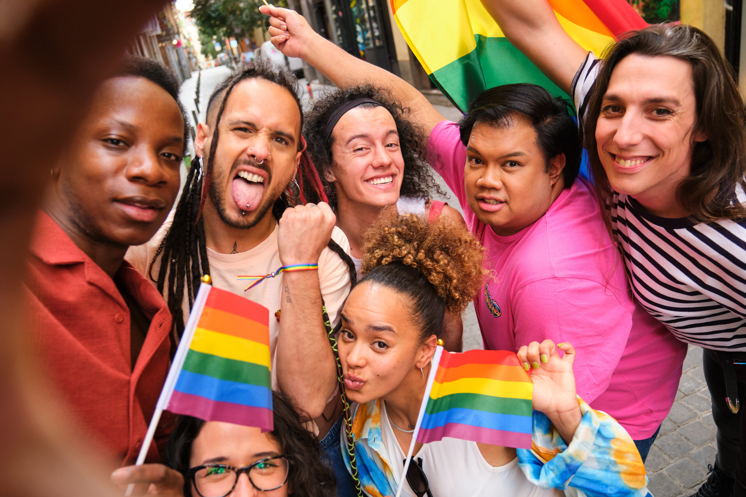 Friends Holding Pride Flags In City