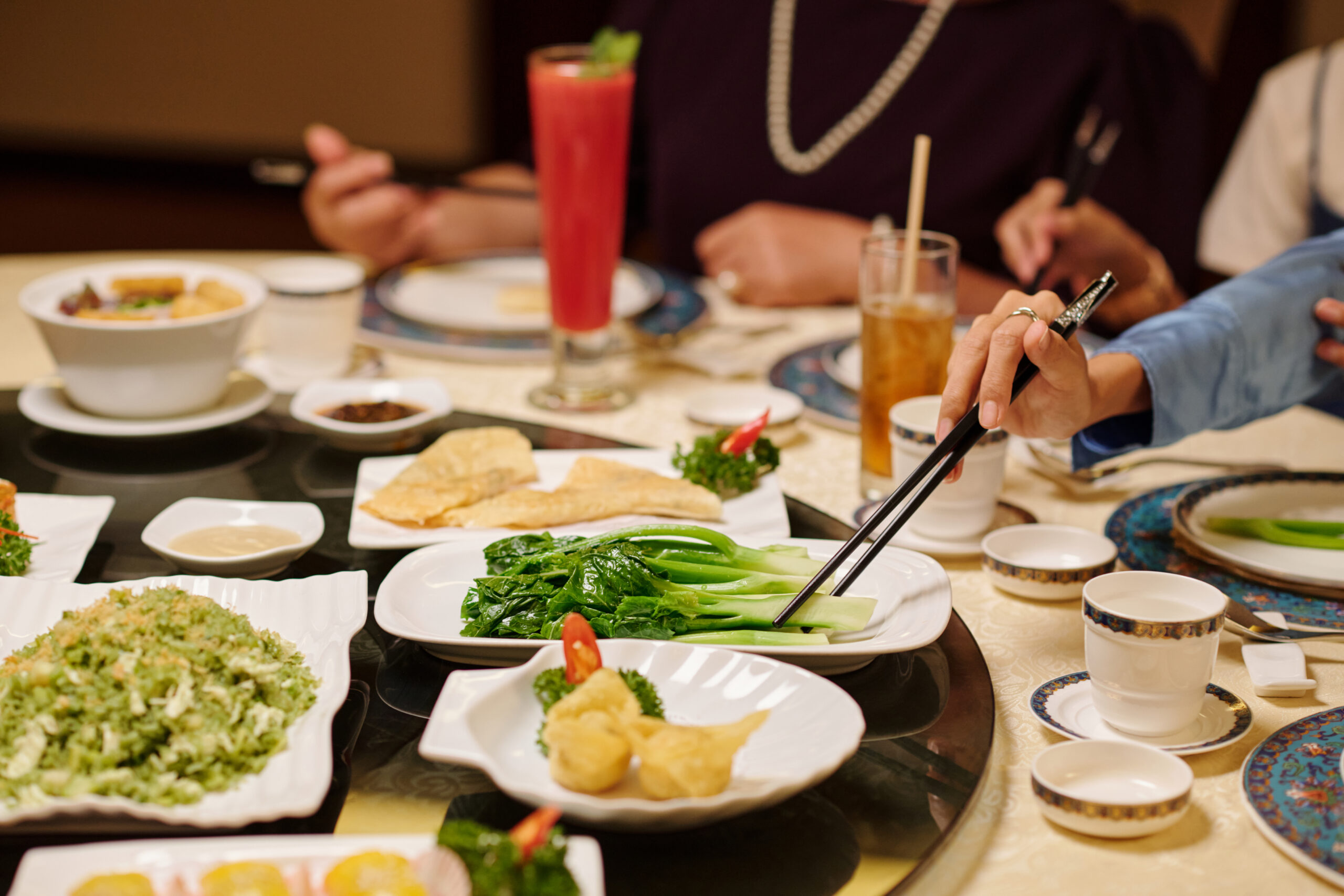 Close-up of people eating Chinese food during meeting in a restaurant