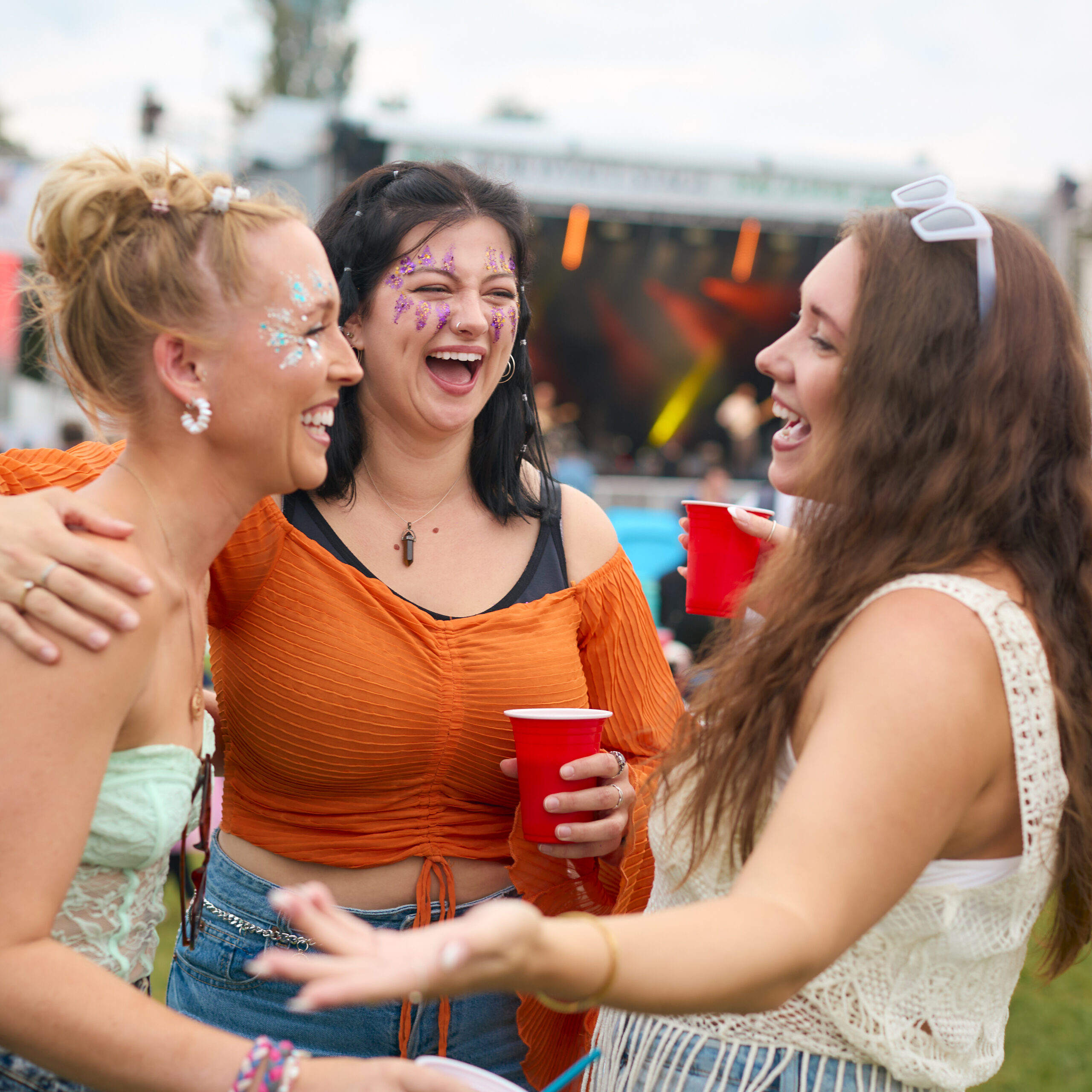 Three Women Laughing At An Outdoor Music Event Love Supreme