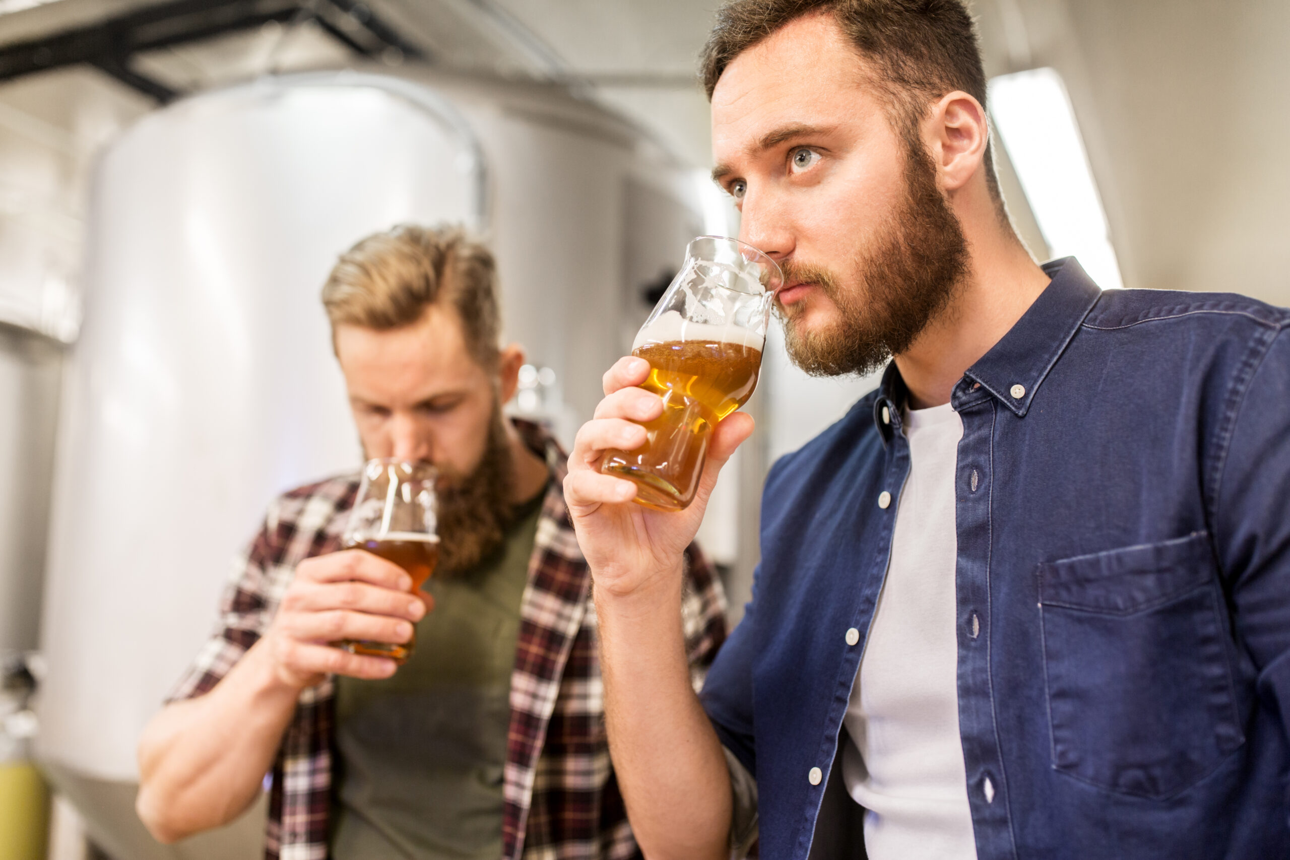 Two Men Taste Testing Beer At A Brewery