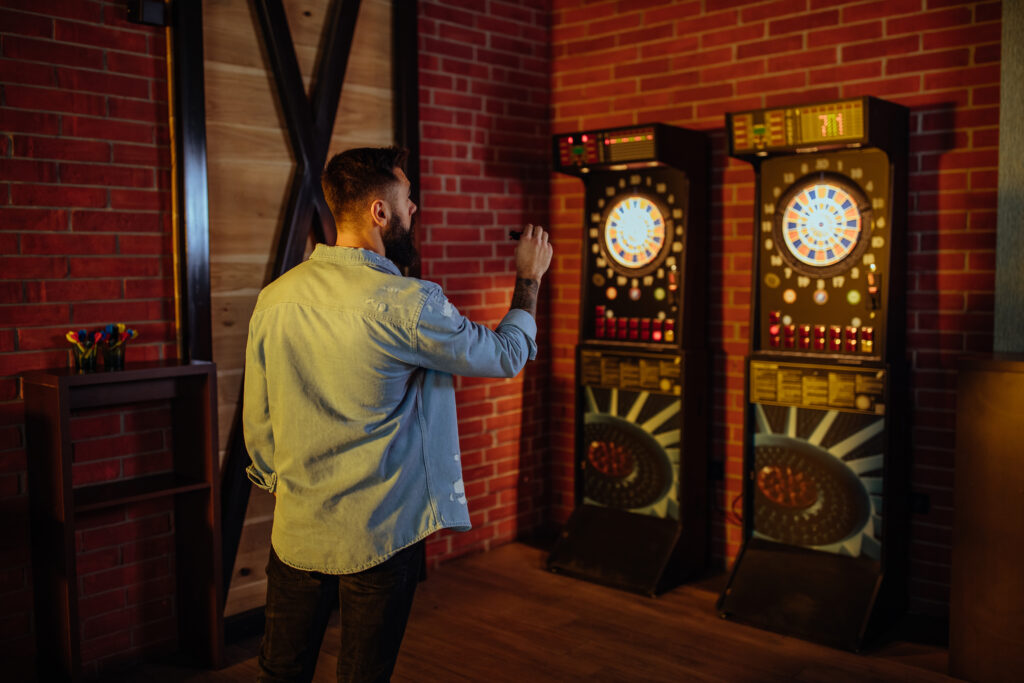 Man Playing Darts In An Indoor Game Room