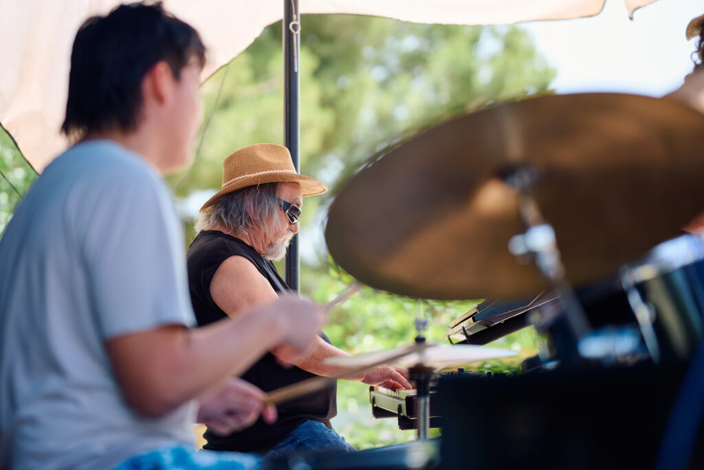 Musicians play instruments at a lively outdoor event