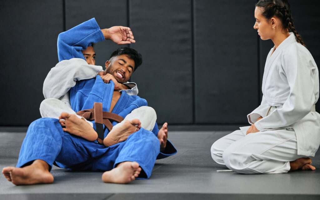 Two Men Practicing Martial Arts With Woman Watching