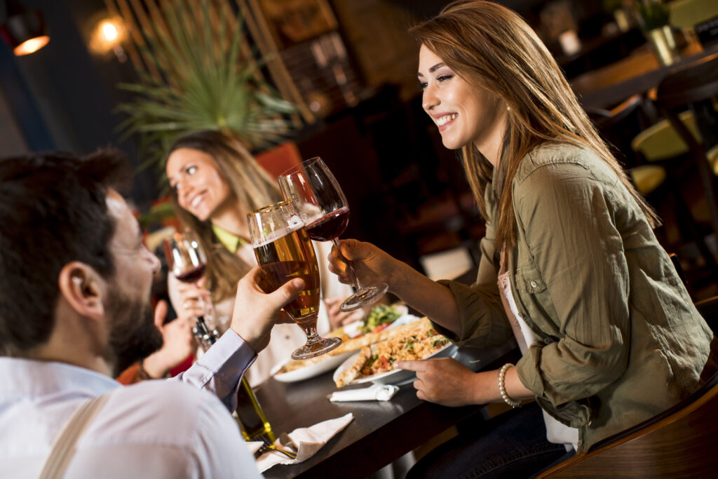 Group of young people having dinner in the restaurant